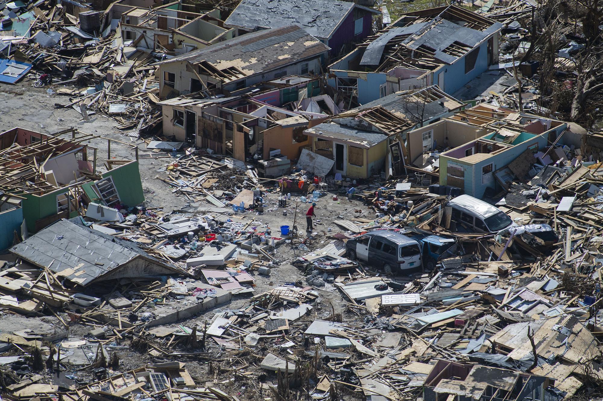 A man goes through the debris in the Mudd and Peas neighbourhoods