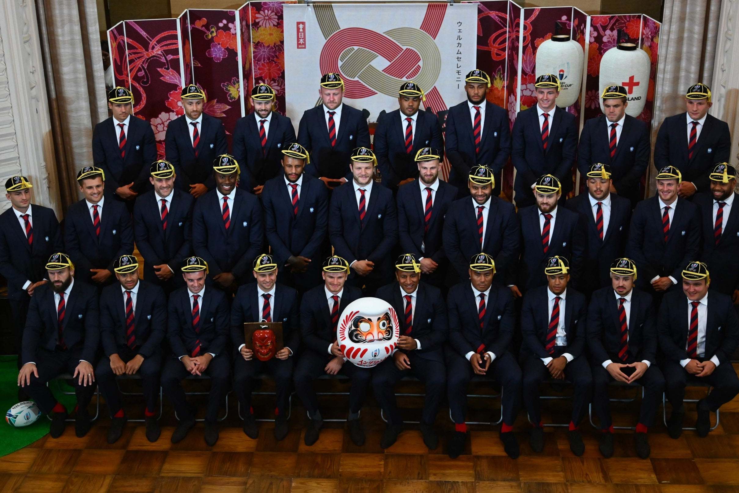 The England rugby squad receive their World Cup caps and show off a Daruma Doll presented to them in Miyazaki