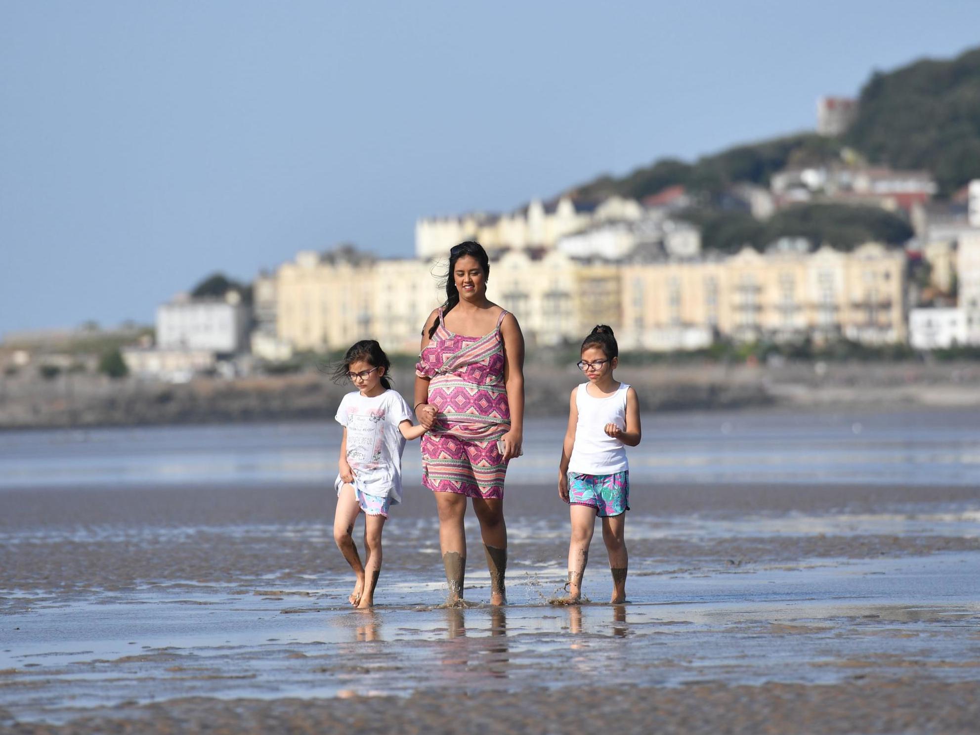 People enjoy the sunshine on the beach at Weston-super-Mare, as temperatures soar this weekend