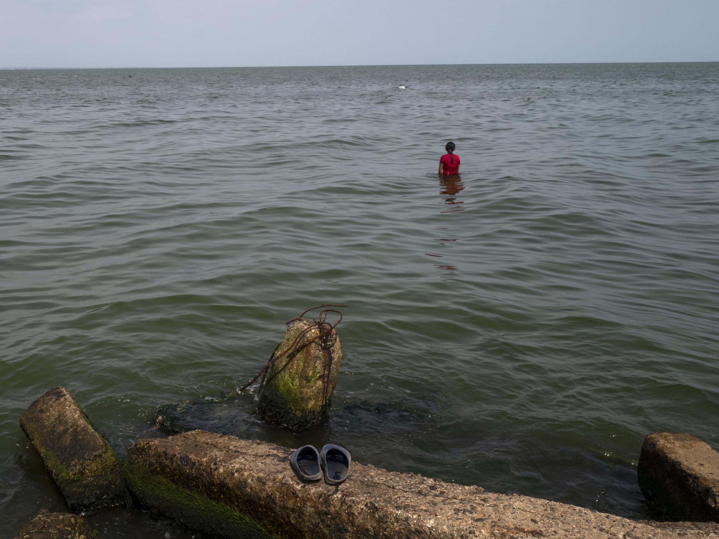 People escape the heat and humidity in the polluted waters of Lake Maracaibo