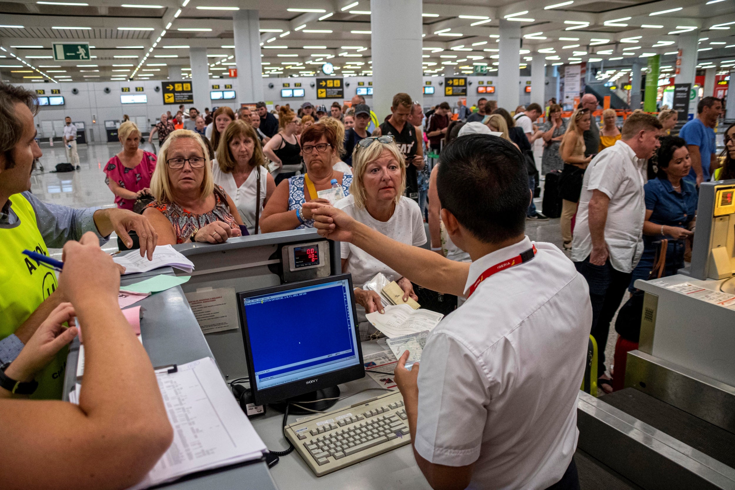 Passengers wait to be helped at Palma airport after Thomas Cook cancelled their flights