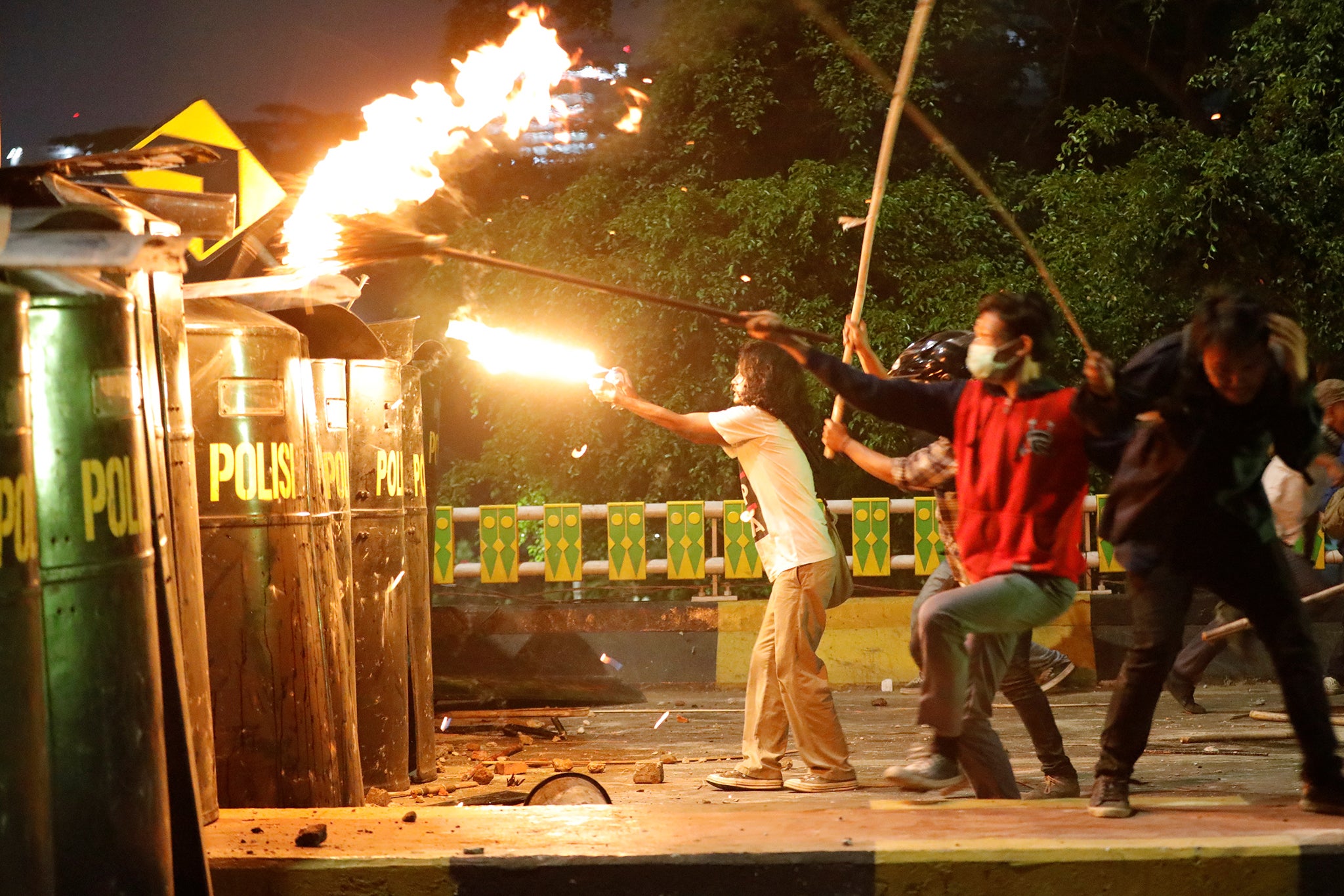 A protester fires at riot police during university students’ protest outside the Indonesian Parliament in Jakarta