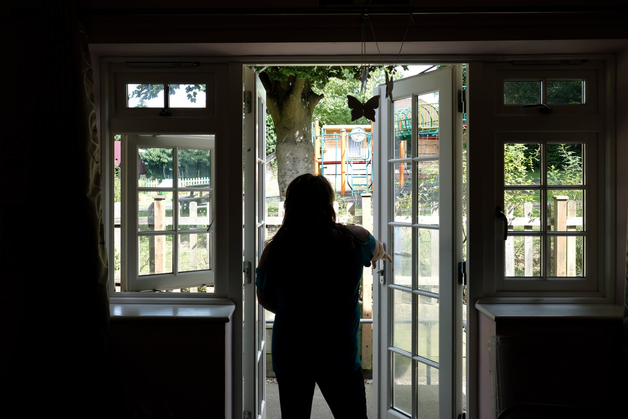 A resident at the refuge looks out into the garden and children's outdoor play area