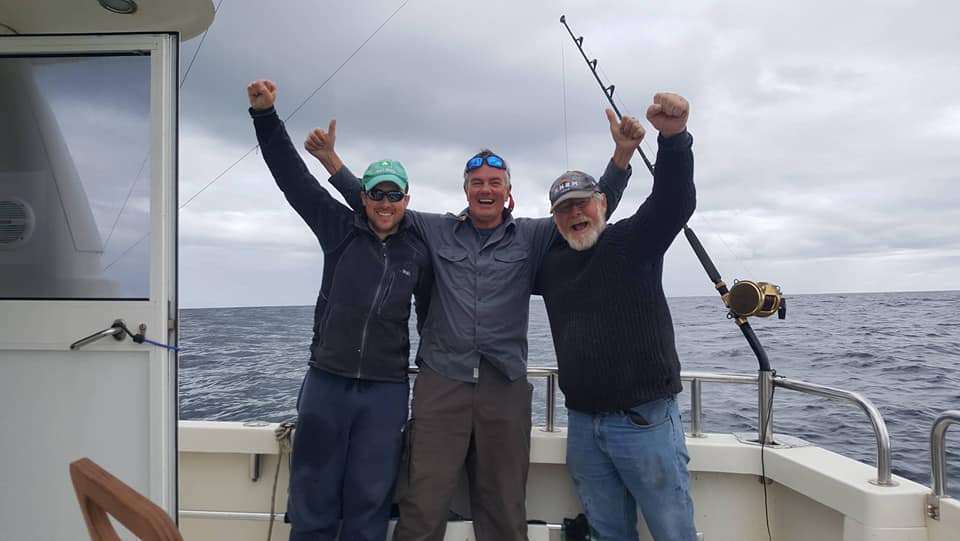 The crew celebrate after reeling in the colossal fish