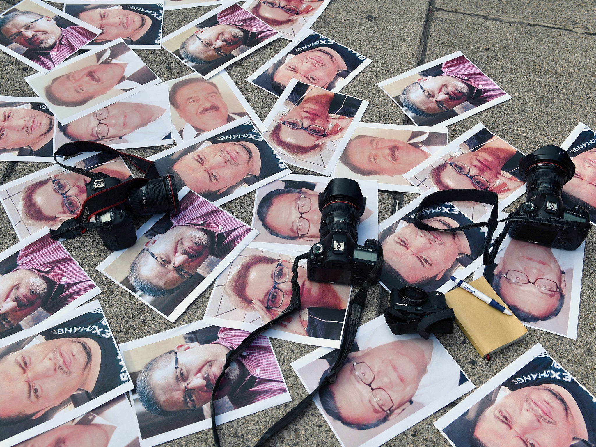 Cameras and pictures of murdered journalists laid out during a protest in Mexico – the country ranks third in the world for the number of journalists killed