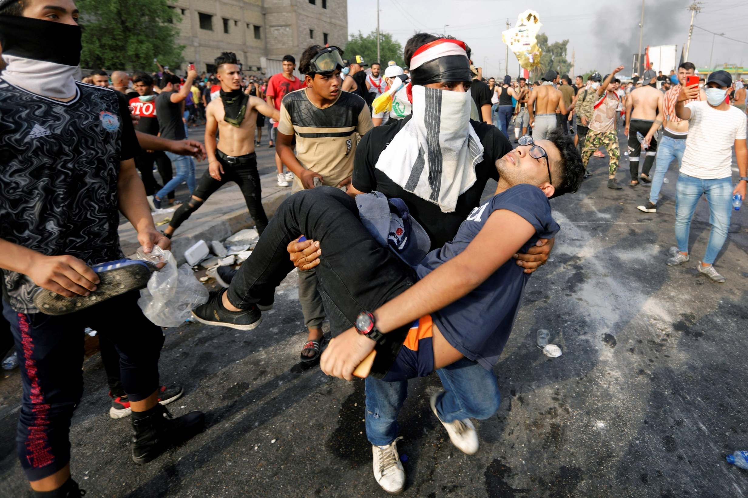 An injured demonstrator is carried away in Baghdad (Reuters)