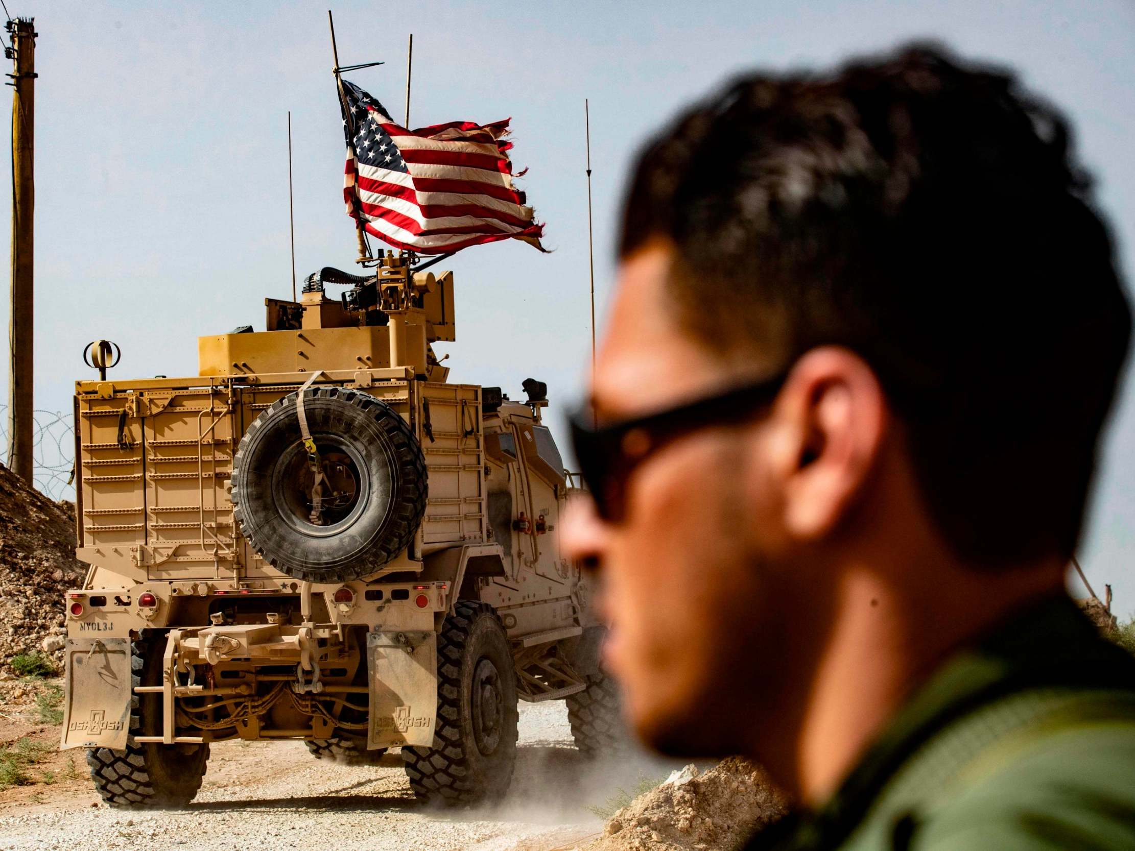 A US soldier sits atop an armoured vehicle during a demonstration by Syrian Kurds against Turkish threats (AFP/Getty)