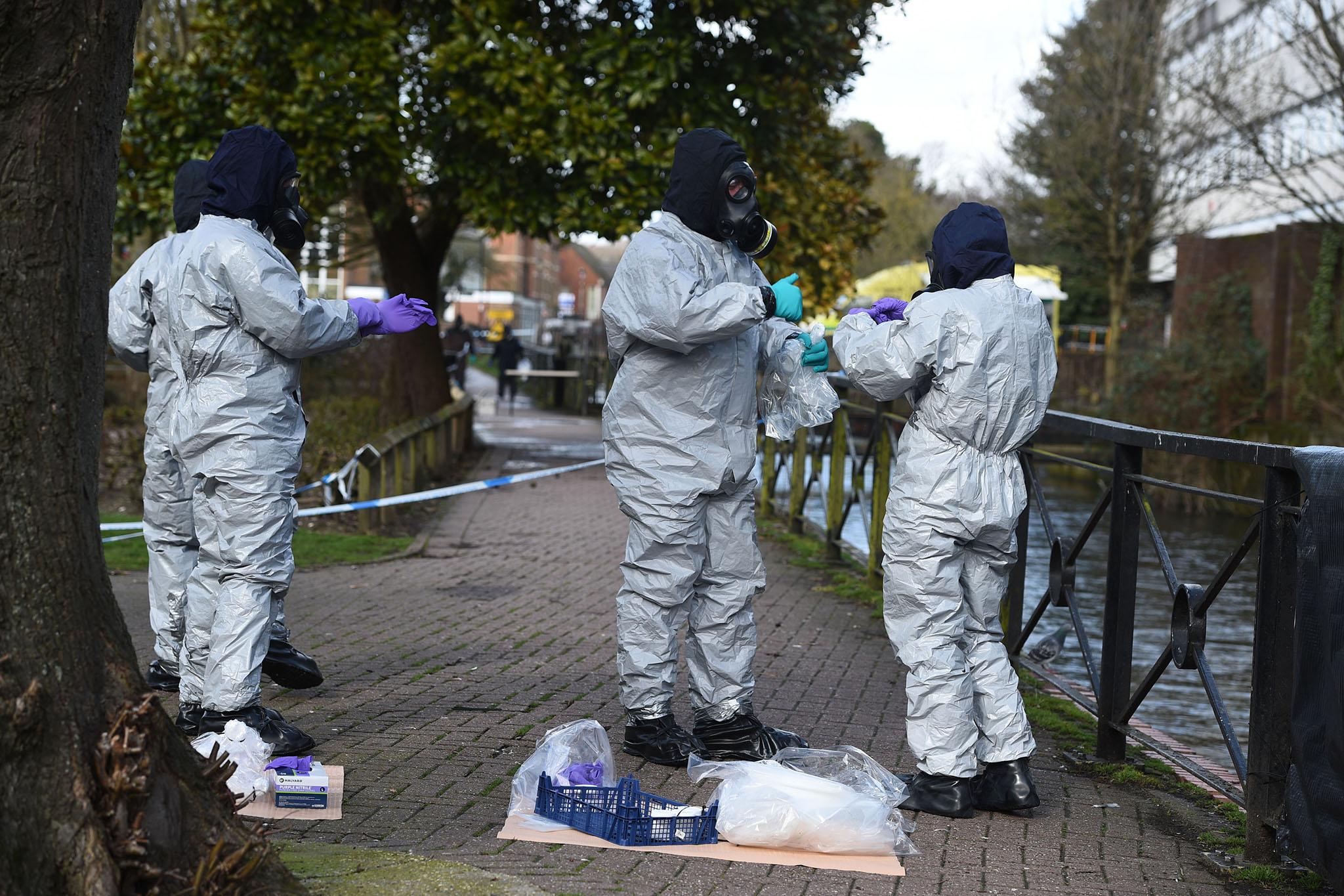 Police teams bag up swabs from railings outside the shopping centre where the Skripals were found critically ill
