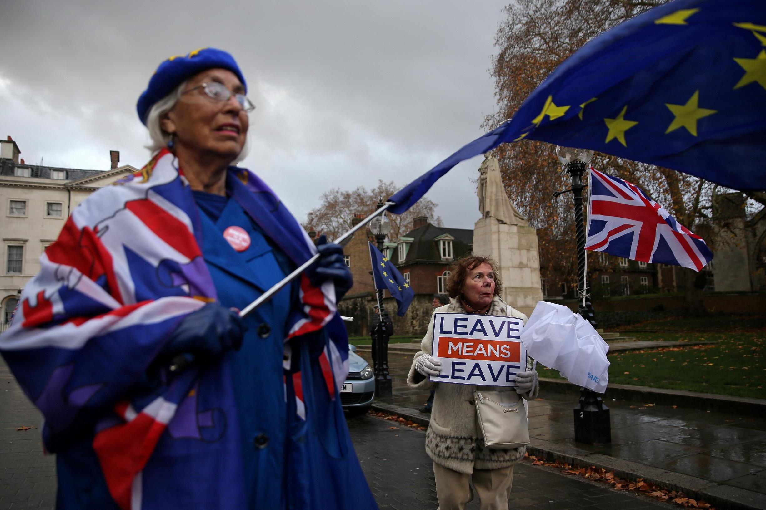 An anti-Brexit protester (left) waves an EU flag as she stands with a pro-Brexit demonstrator (AFP/Getty)