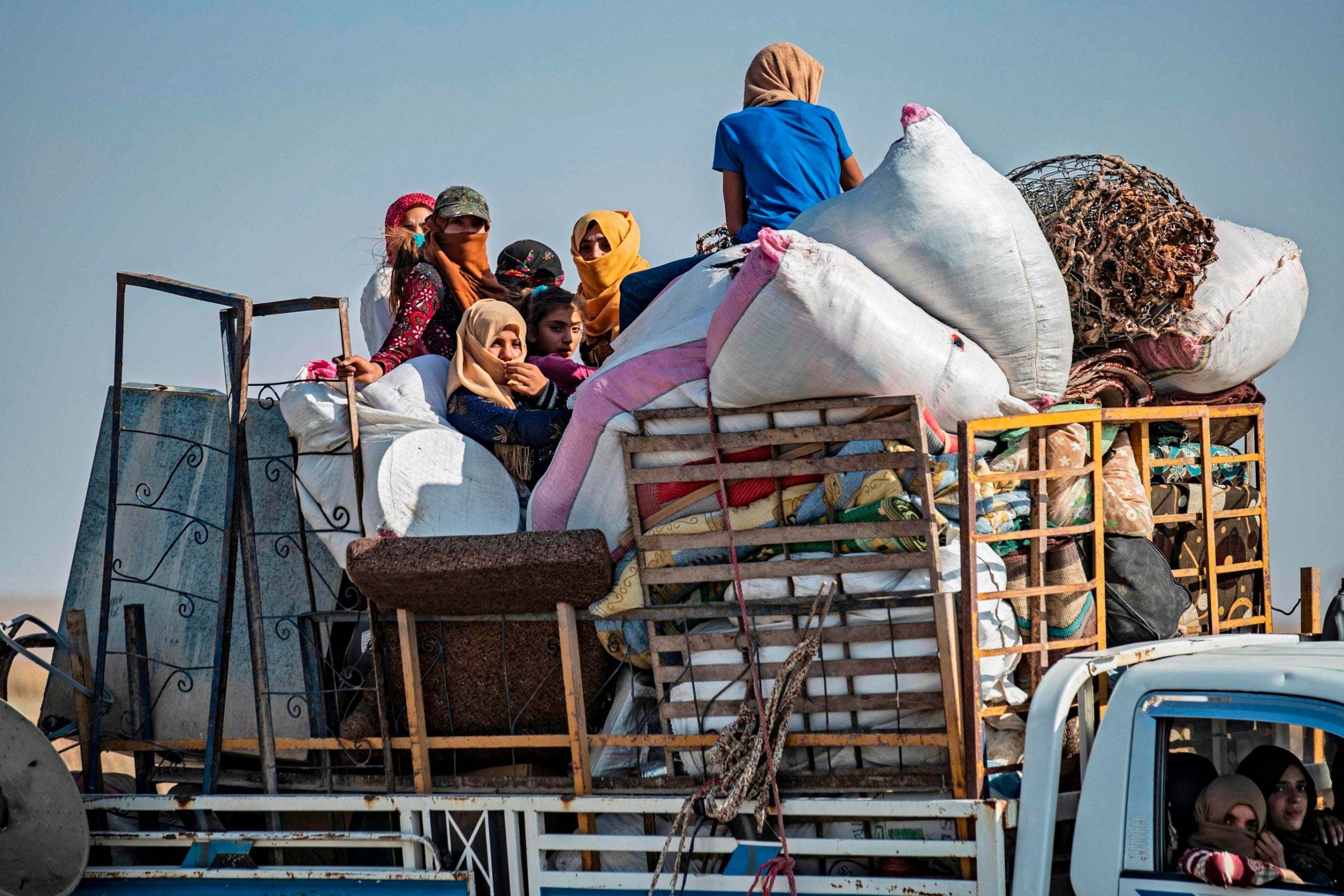 Syrian Arab and Kurdish civilians arrive to Tall Tamr town, in the Syrian northwestern Hasakeh province, after fleeing Turkish bombardment on the northeastern towns along the Turkish border on October 10, 2019.