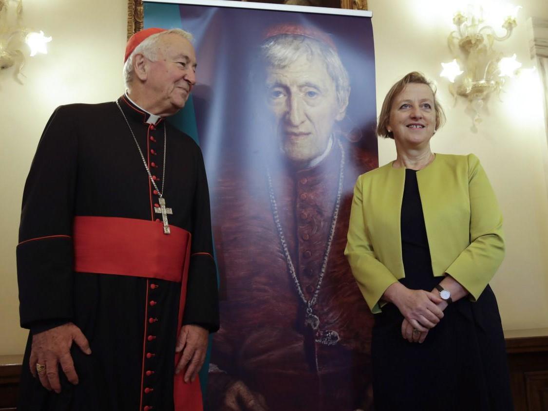 Cardinal Vincent Nichols and Sally Jane Axworthy, the British Ambassador to the Holy See, stand in front of picture of Cardinal John Henry Newman ahead of his upcoming canonisation