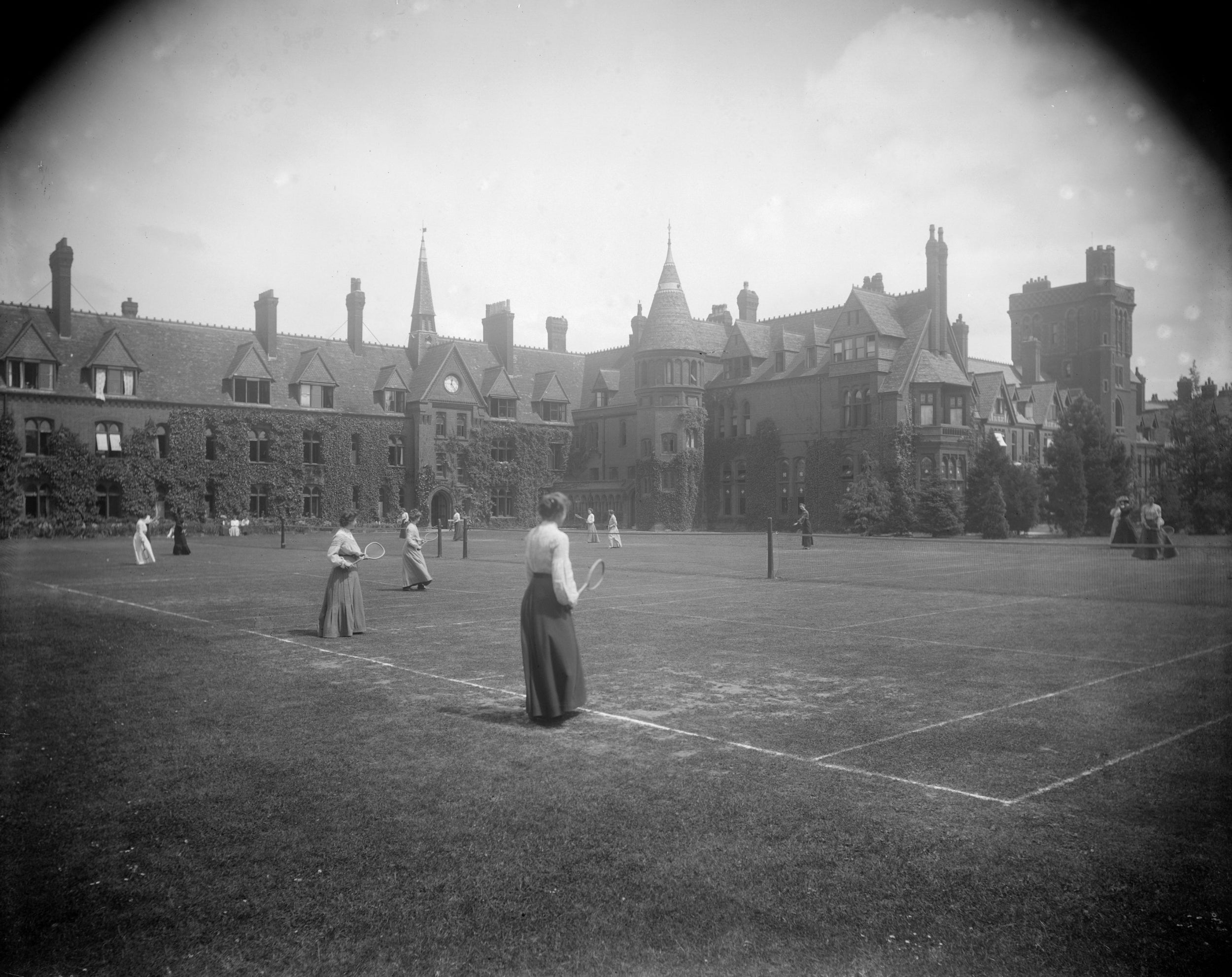 Female undergraduates playing tennis in the grounds of Girton