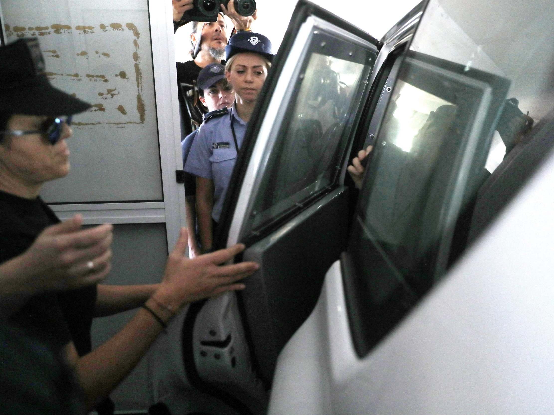 A British teenager is escorted into a vehicle outside the Famagusta courthouse after a custody hearing in Paralimni, Cyprus.