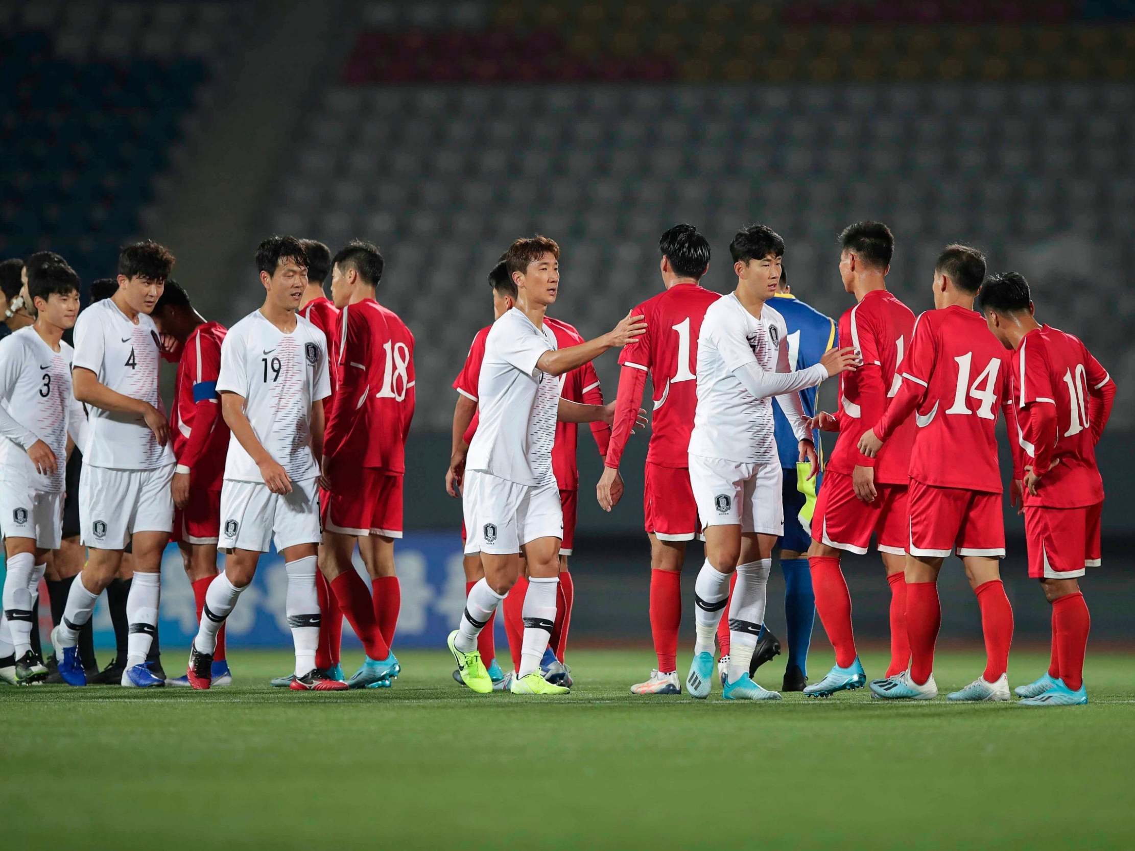 Tottenham's Son Heung-min, right in white, shakes hands with North Korean players