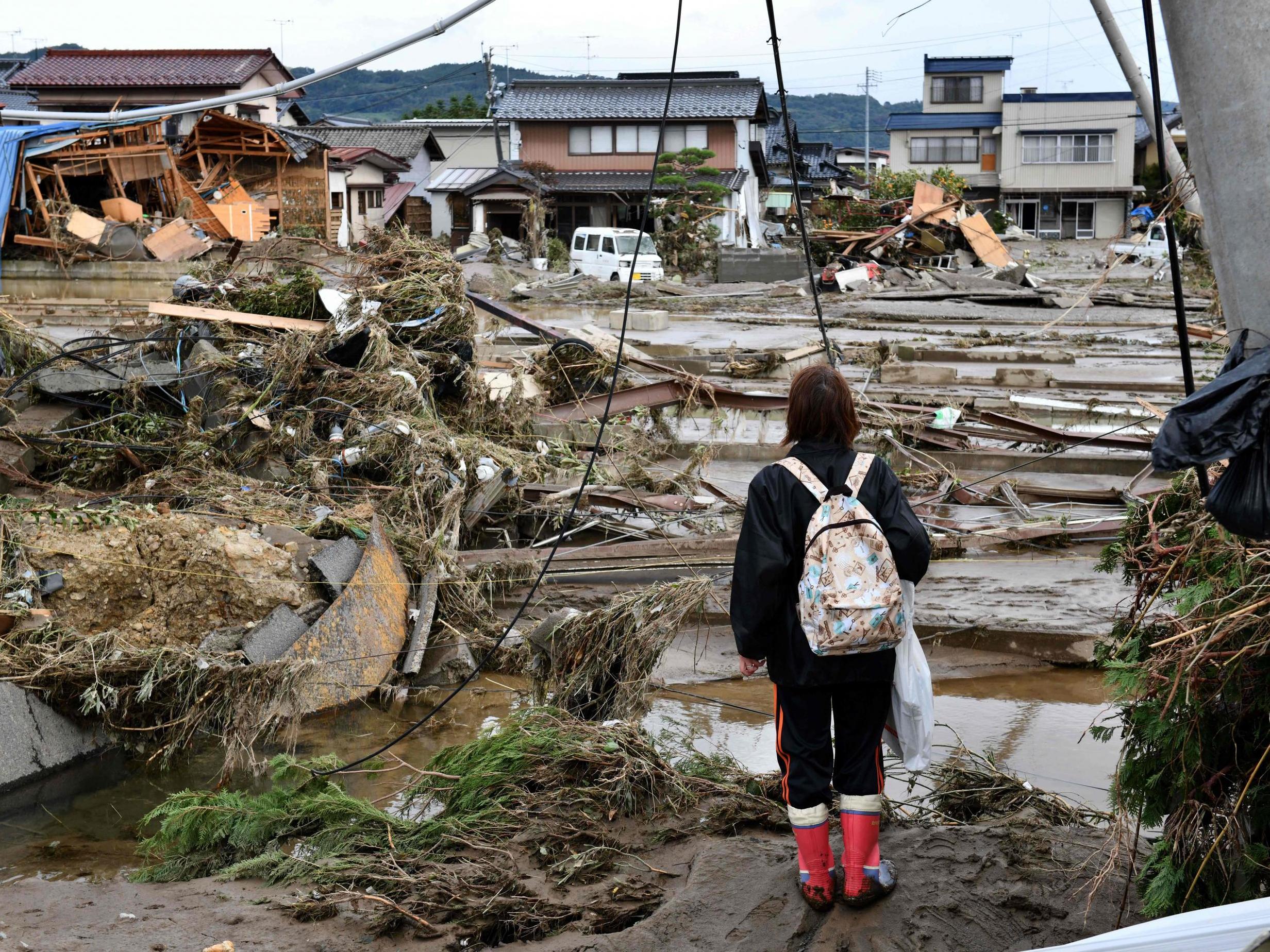 A woman looks at flood-damaged homes in Nagano after Typhoon Hagibis