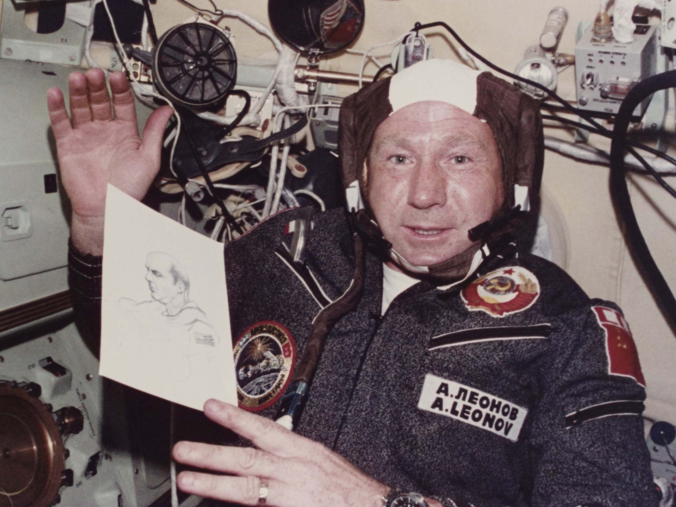 Leonov shows his drawing of Apollo commander Thomas P Stafford during a mission in July 1975