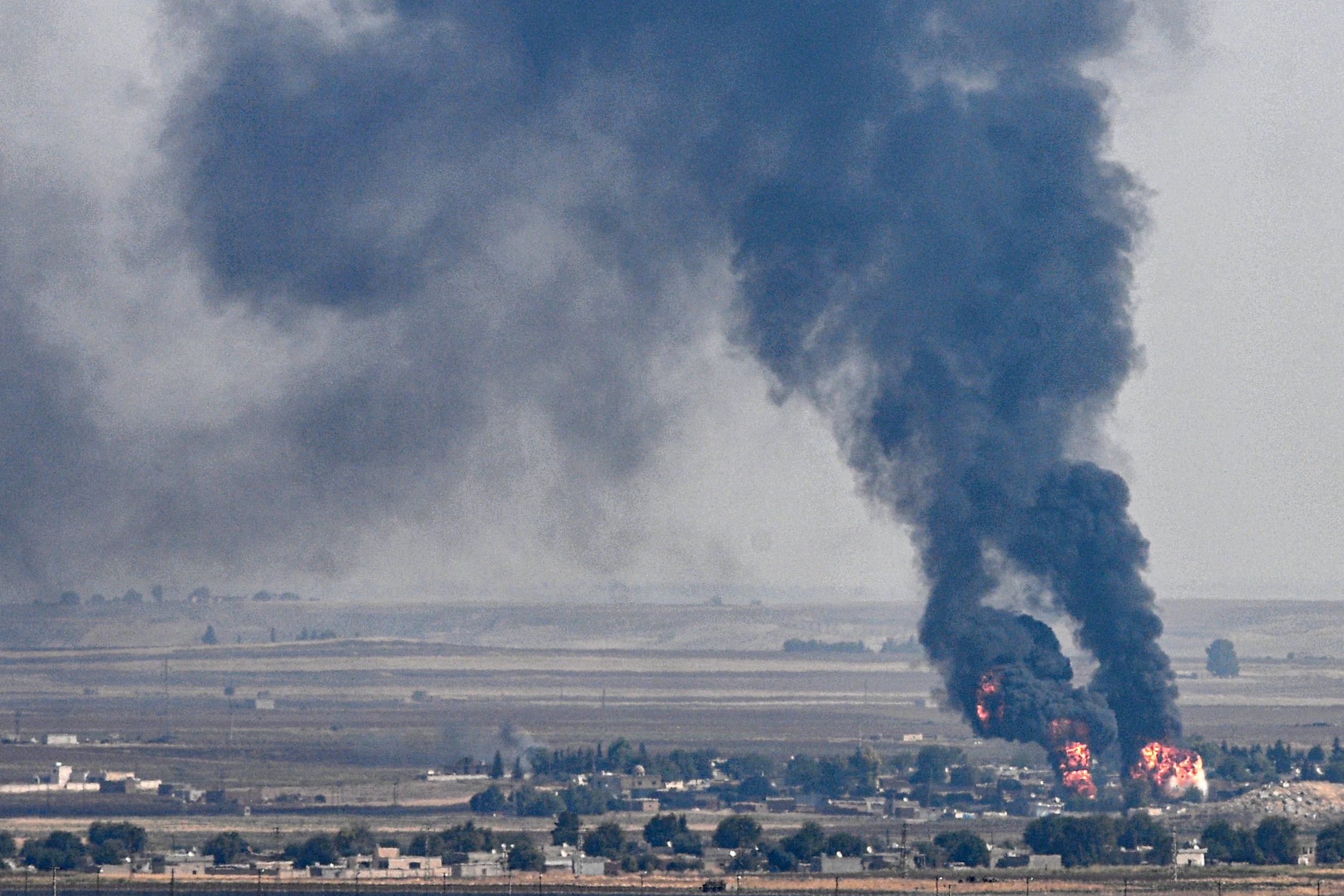 The Turkish side of the border with Syria in the Ceylanpinar district city of Sanliurfa shows smoke and fire rising from the Syrian town of Ras al-Ain where Kurdish officials want a humanitarian corridor