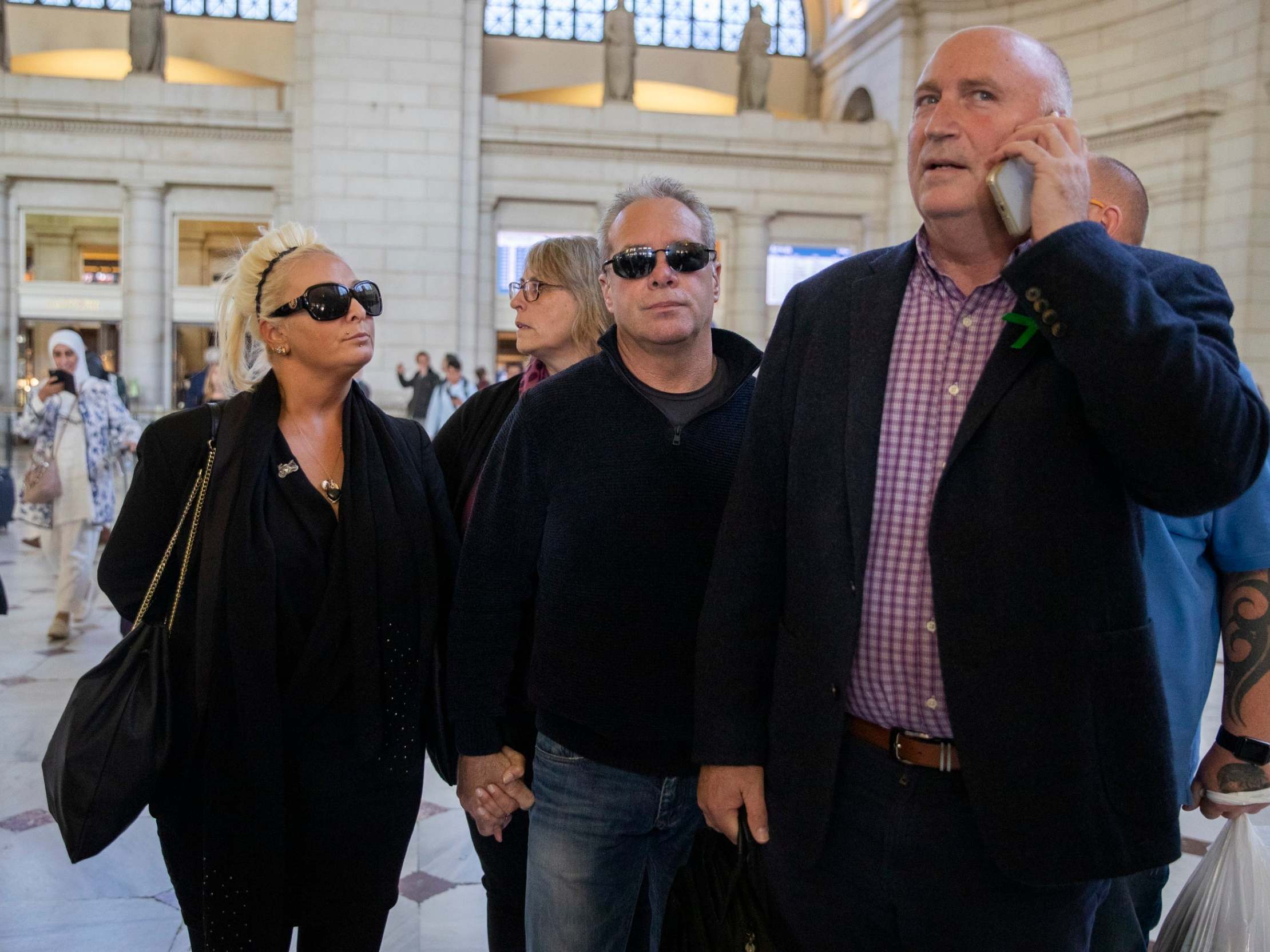 Charlotte Charles, on left, the mother of Harry Dunn, stands in Washington with her husband, Bruce Charles. Family lawyer Radd Seiger is on the phone.