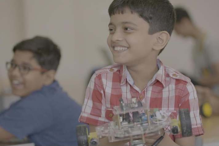 A Stem student holds up a robot he programmed at a LearnOBots workshop (Matt Kay and Andrew Carver)