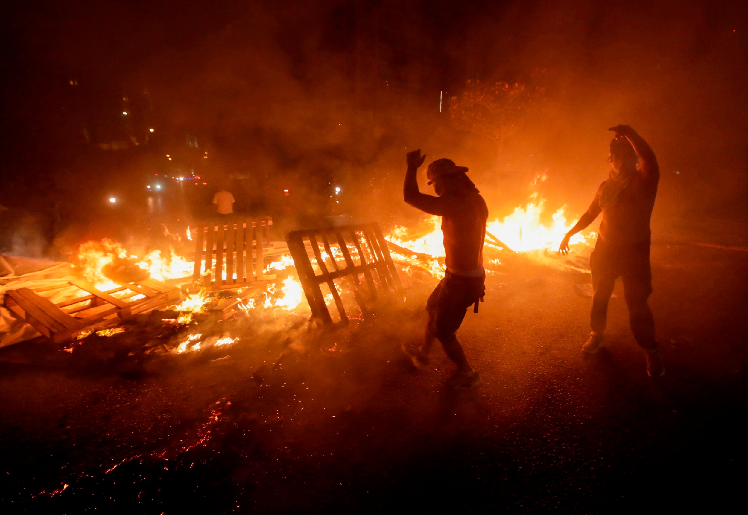 Demonstrators burn wood and debris during a protest against recent tax calls on October 17 in Beirut