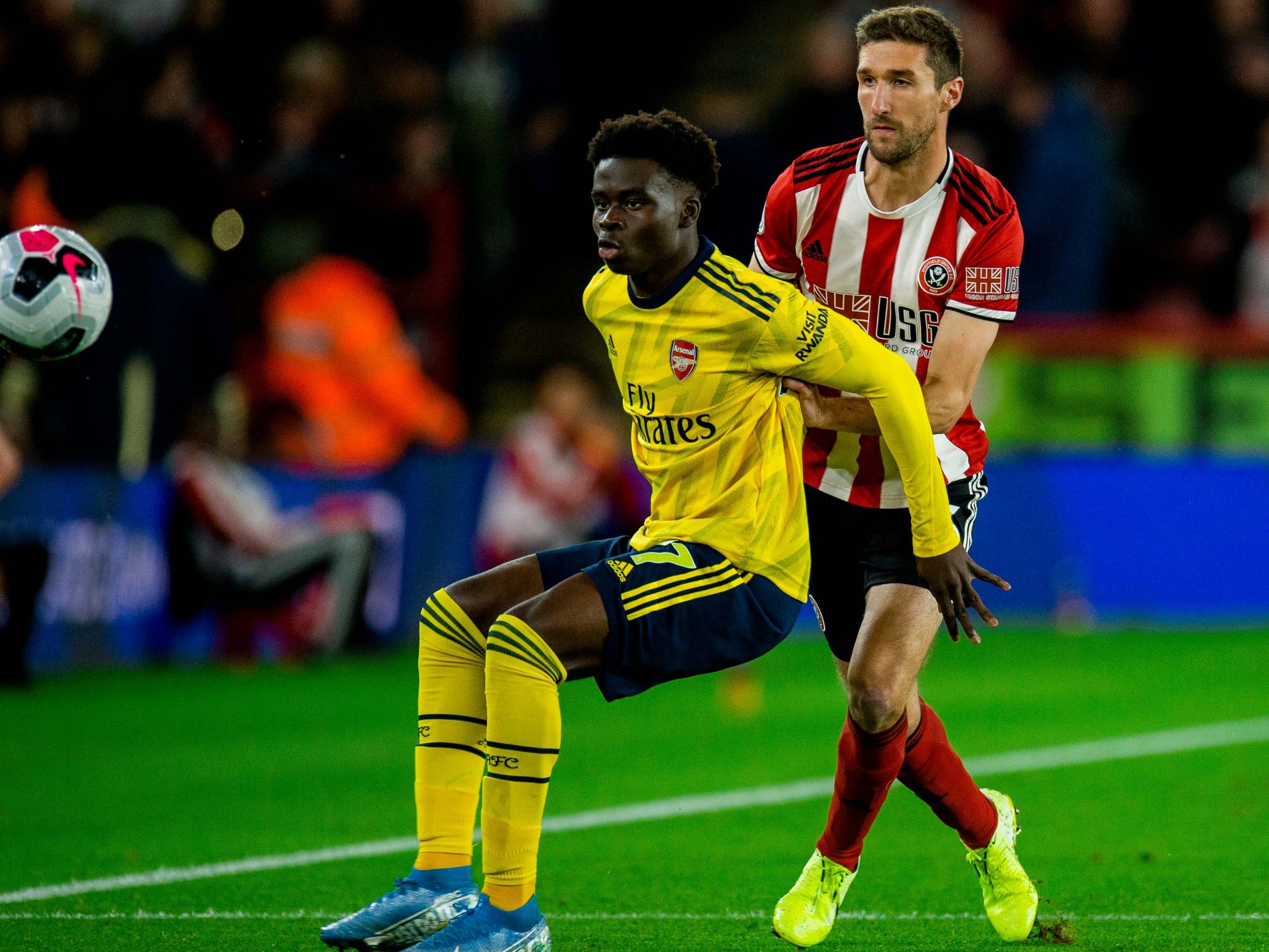 Arsenal's Bukayo Saka tries to hold off Chris Basham