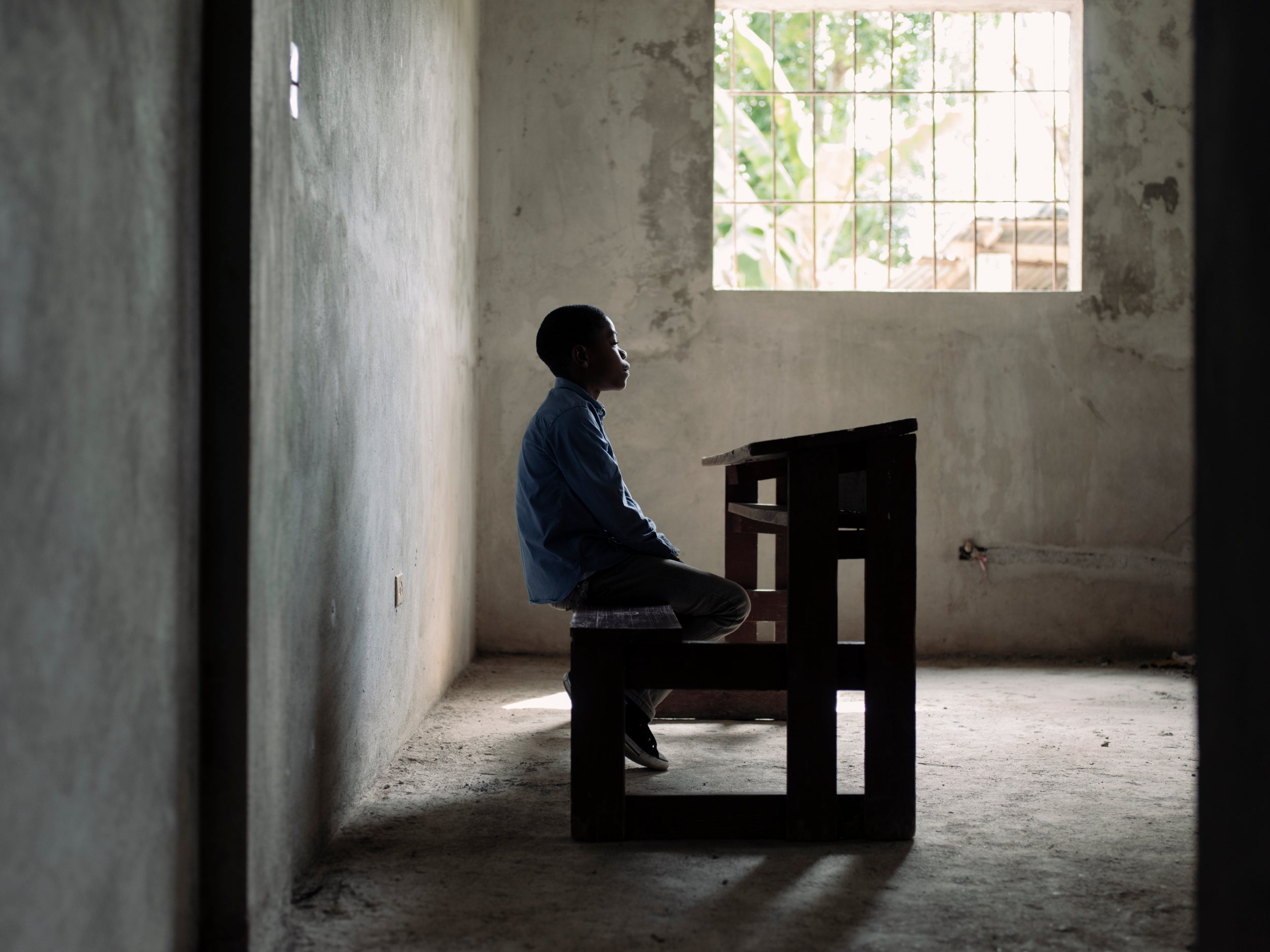Esperence, 10, goes to Perigny school. Seated on a bench at the end of a long dark corridor, overcome with emotion, he explains how he was given up by his biological parents at the age of eight. He now lives with his auntie and is a restavek child. The term ‘restavek’ comes from the French rester avec, ‘to stay with’. Discussing the work around the house he has to complete as part of his daily chores, he explains: ‘I can never go out and play with my friends as my house family always call me back inside to do more jobs.’