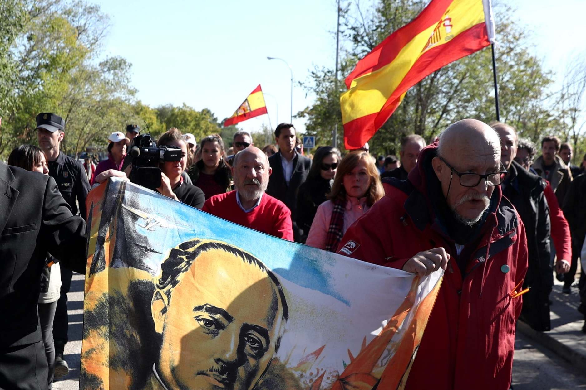 Supporters of Franco hold a flag with his portrait outside the cemetery in Madrid (Reuters)