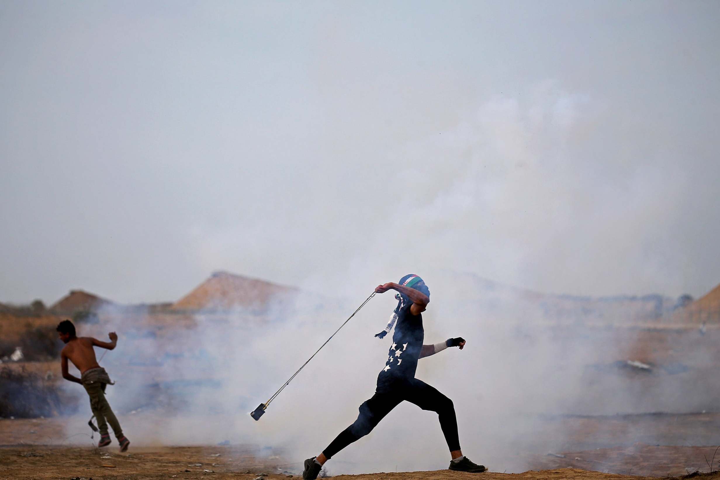 A Palestinian demonstrator hurls back a tear gas canister during an anti-Israel protest at the Israel-Gaza border fence in the southern Gaza Strip in October