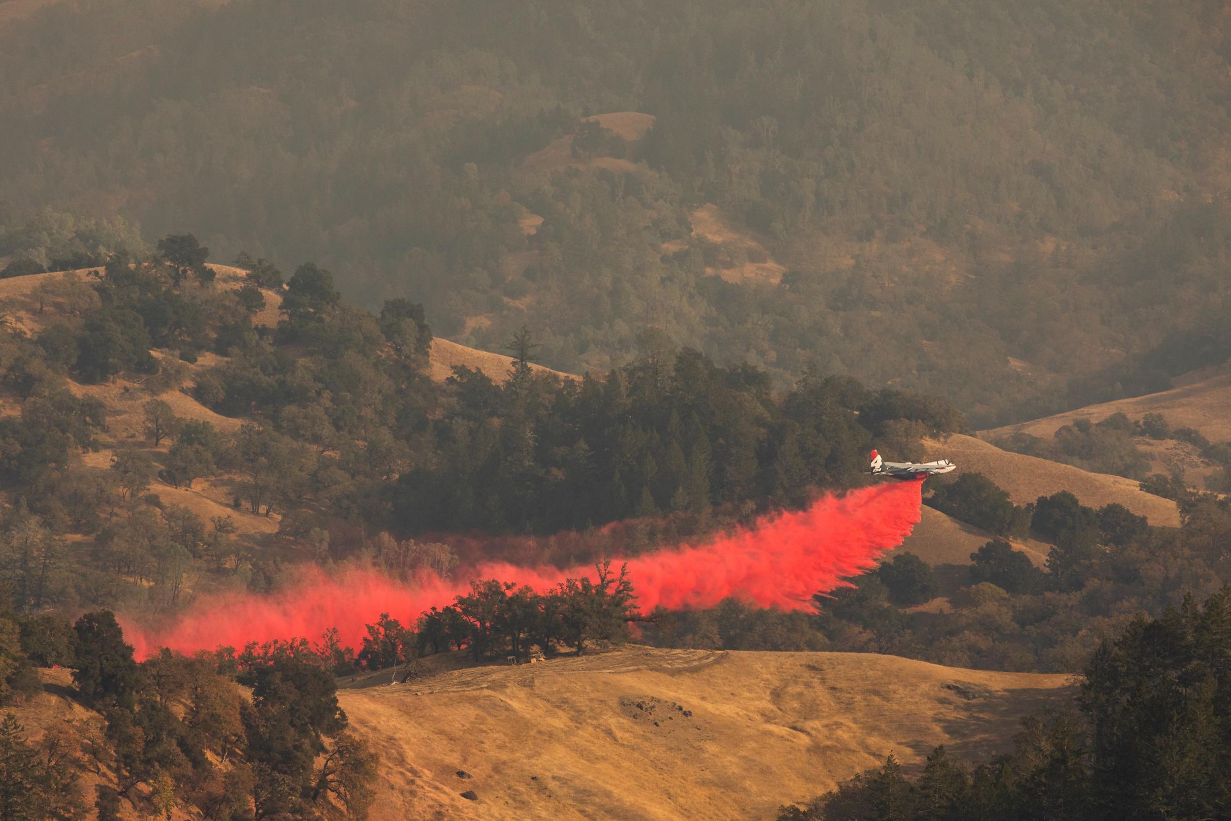 An air tanker drops fire retardant in the valley below in Healdsburg, California, on 26 October 2019