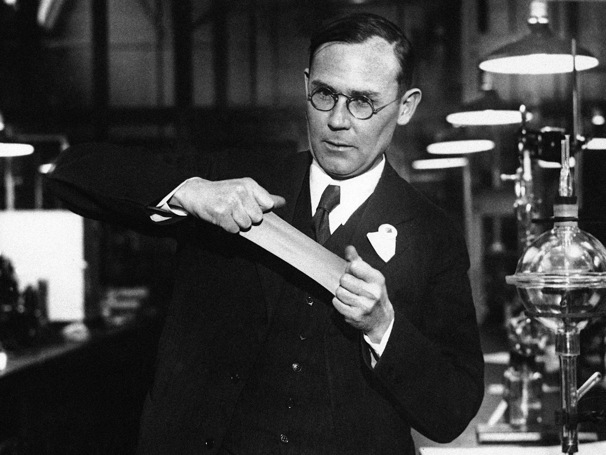 Carothers and a piece of his new synthetic rubber which he demonstrated before the American Chemical Society