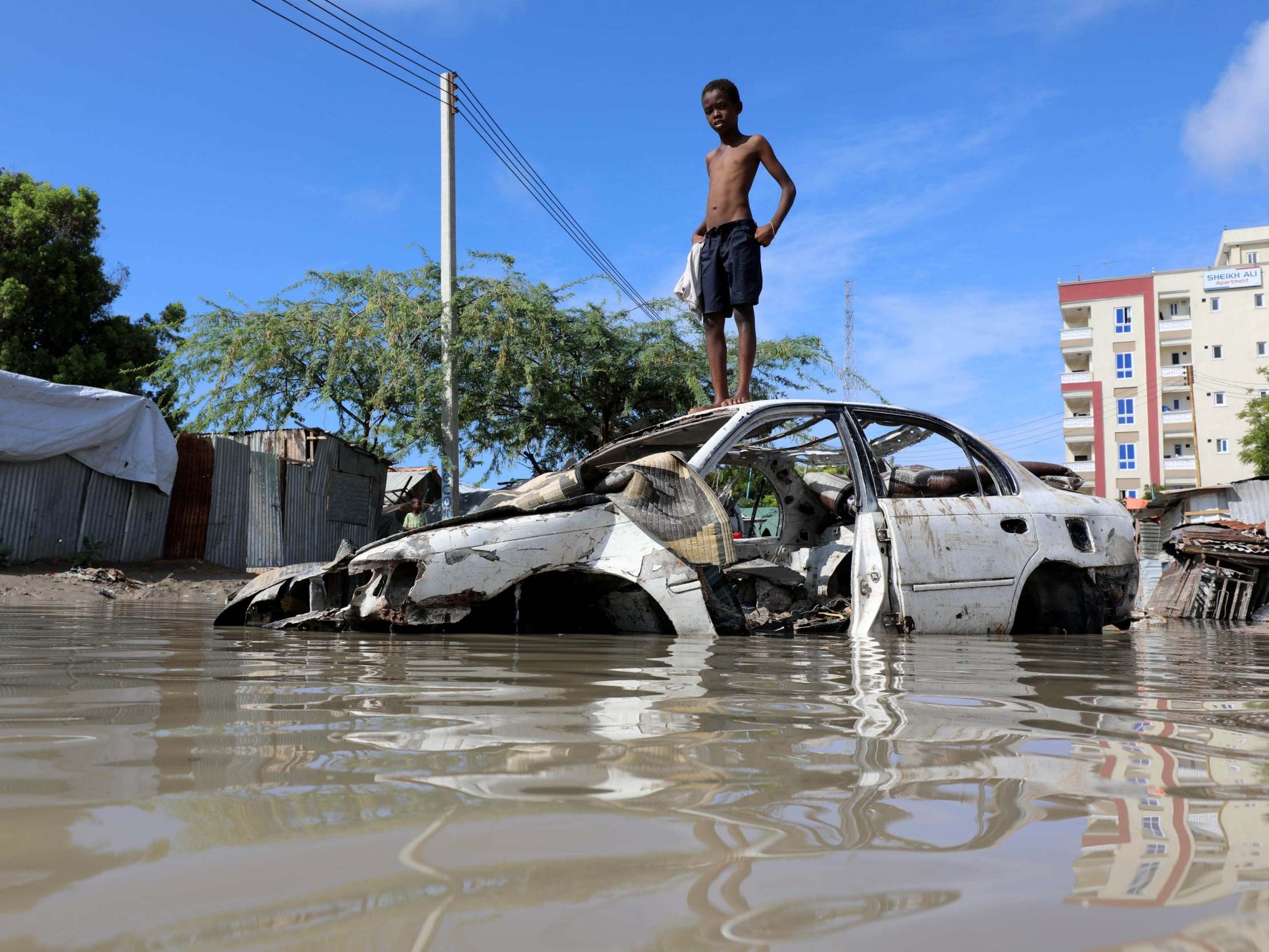 A Somali boy stands on a junk vehicle after heavy rain flooded their neighbourhood in Mogadishu, Somalia, 21 October, 2019.