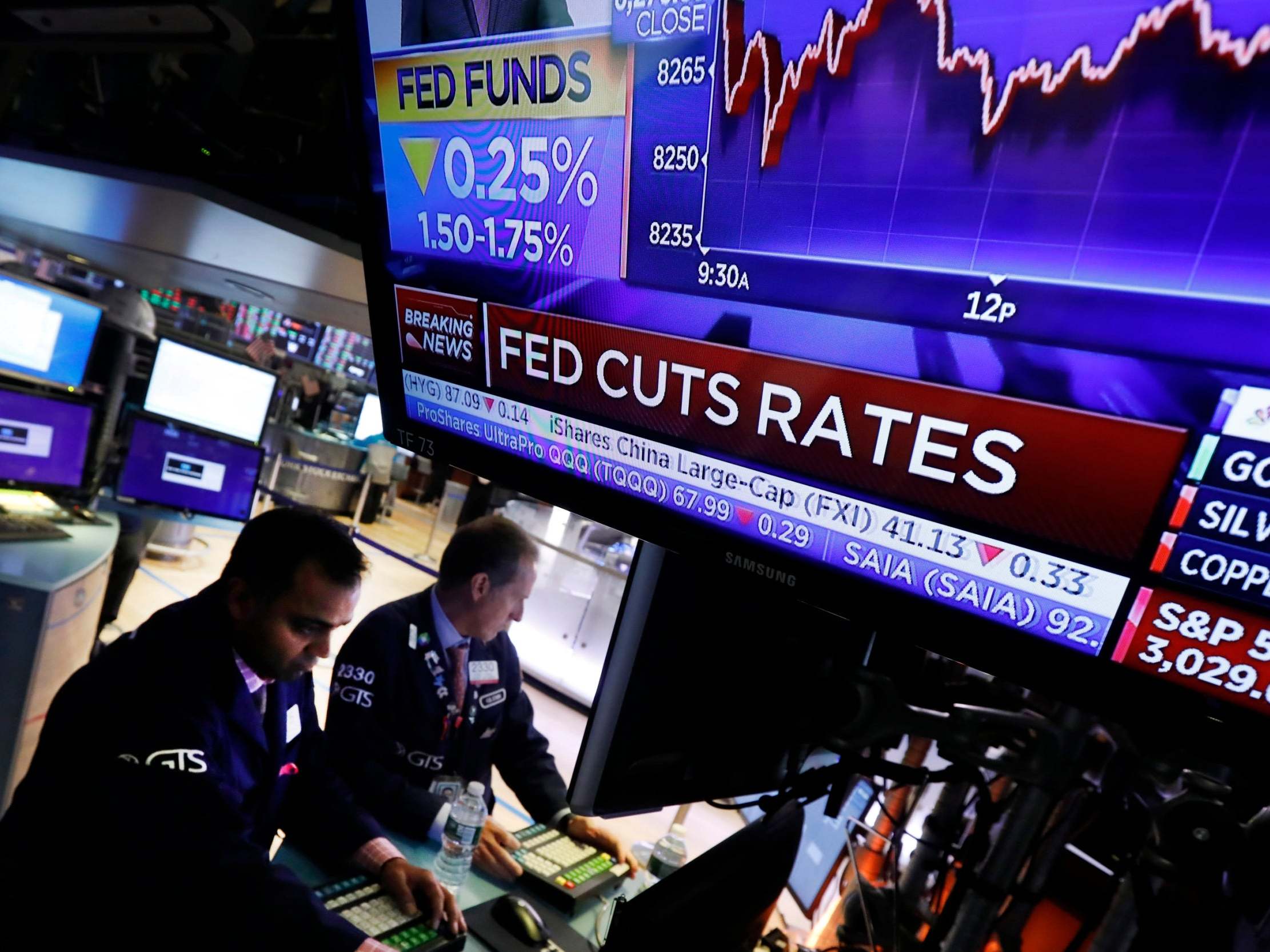 A television screen on the floor of the New York Stock Exchange shows the rate decision of the Federal Reserve