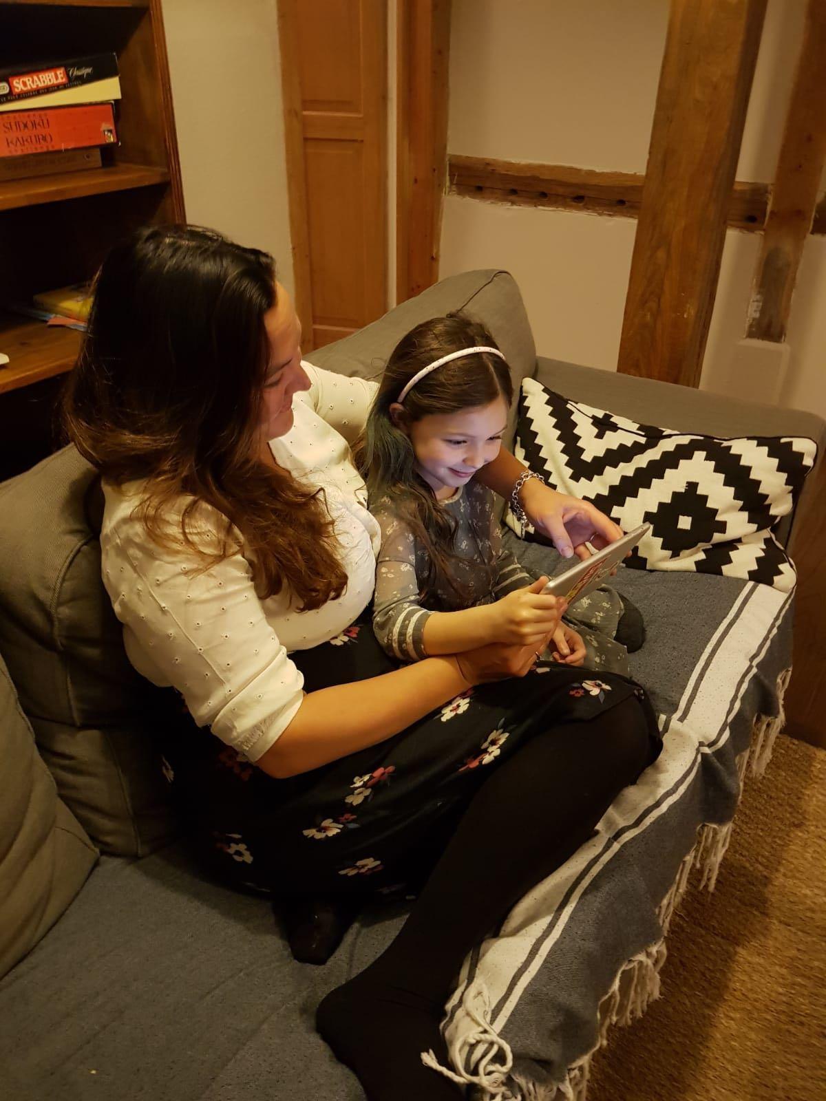 Apolline, 7, pictured with mum Tanya, loves to "listen to the stories and say the words" using the Pickatale app