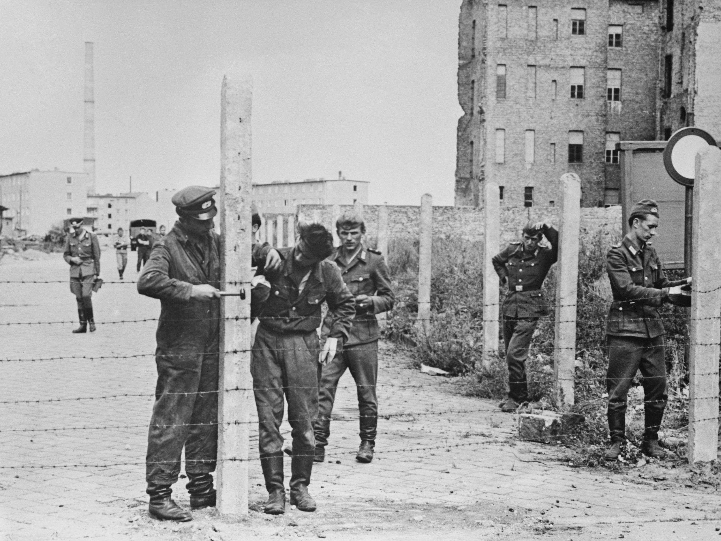 Soldiers of the East German National People’s Army erecting barbed wire fences in 1961