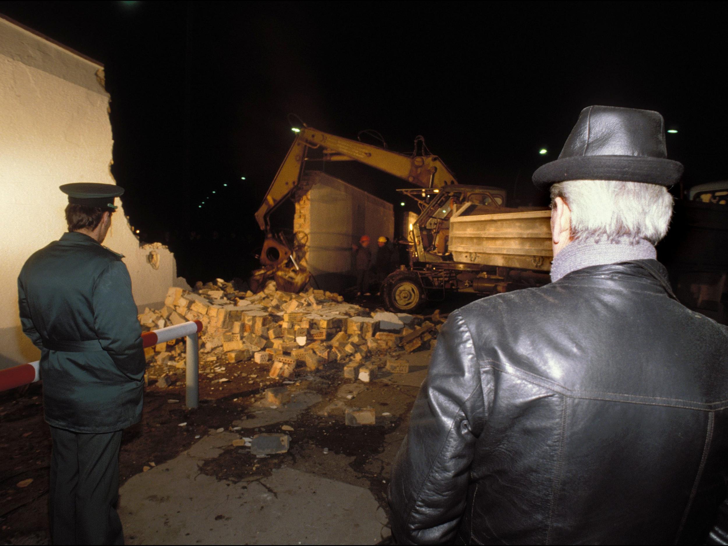 Heavy machinery smashes through the Berlin Wall