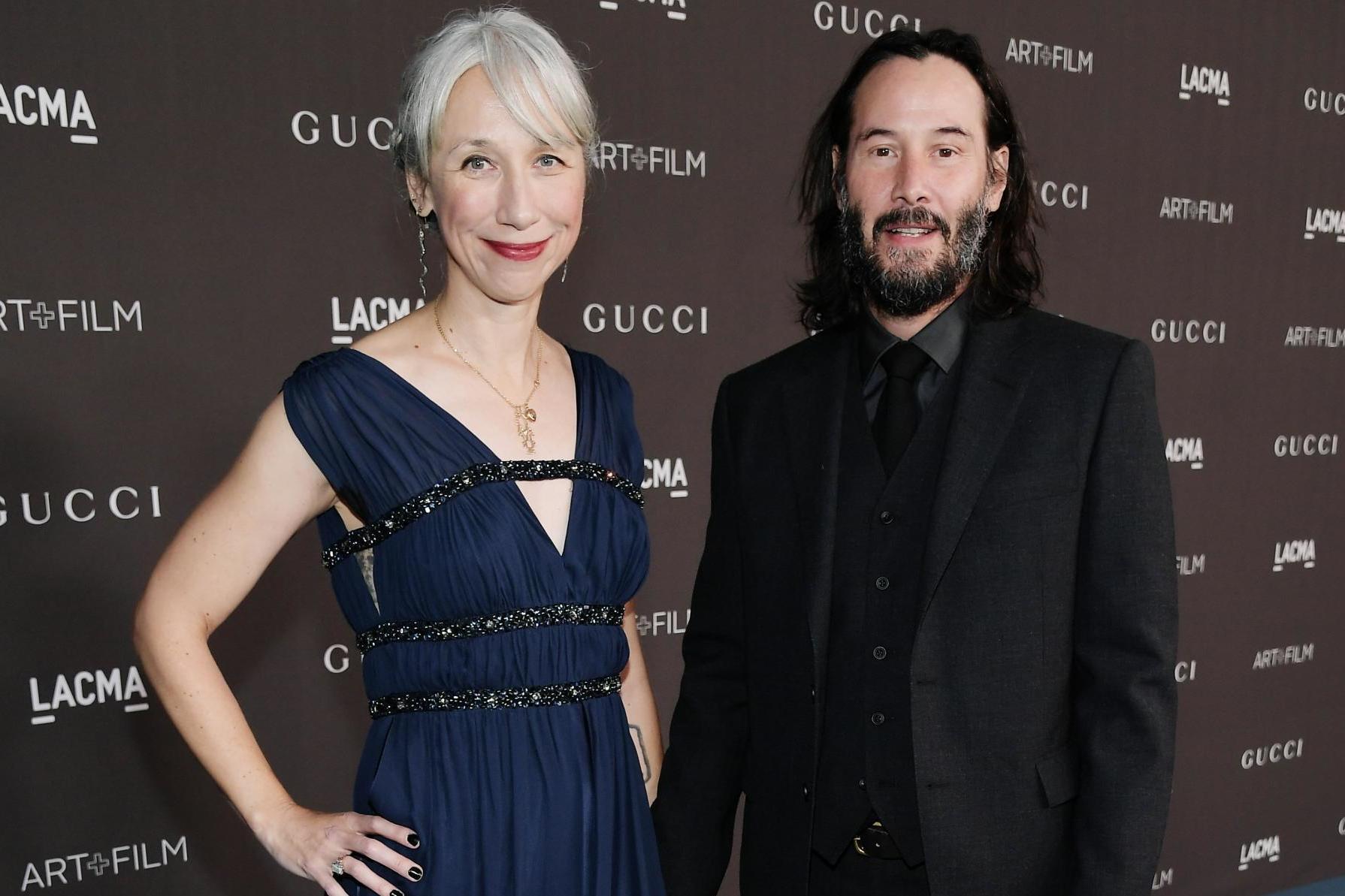 Keanu Reeves holds hands with Alexandra Grant on red carpet (Getty)