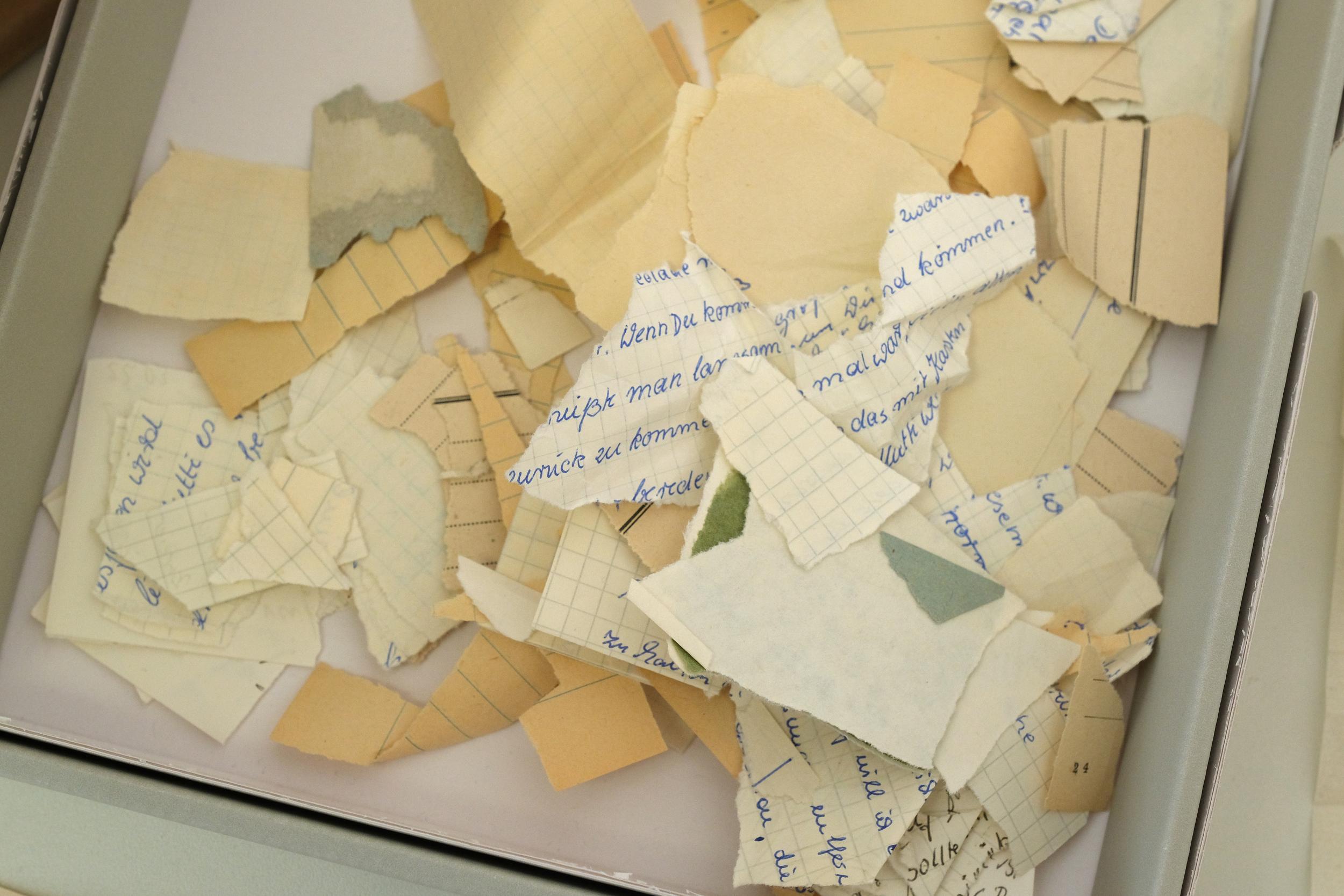 Torn documents that belonged to the spying organisation lie on a table at the archive of the Stasi Records Agency (Getty)