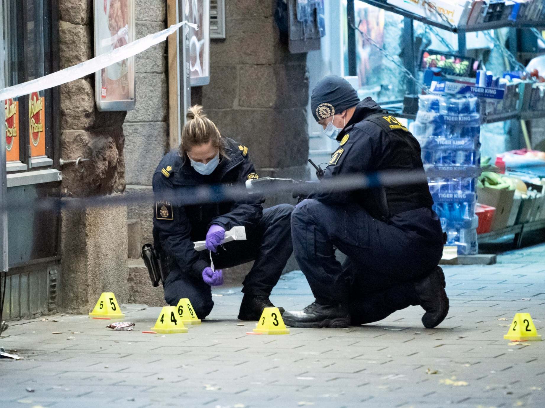 Police forensics examine the crime scene where a 15-year-old was fatally hit and another severely wounded when attackers opened fire in Malmo, Sweden