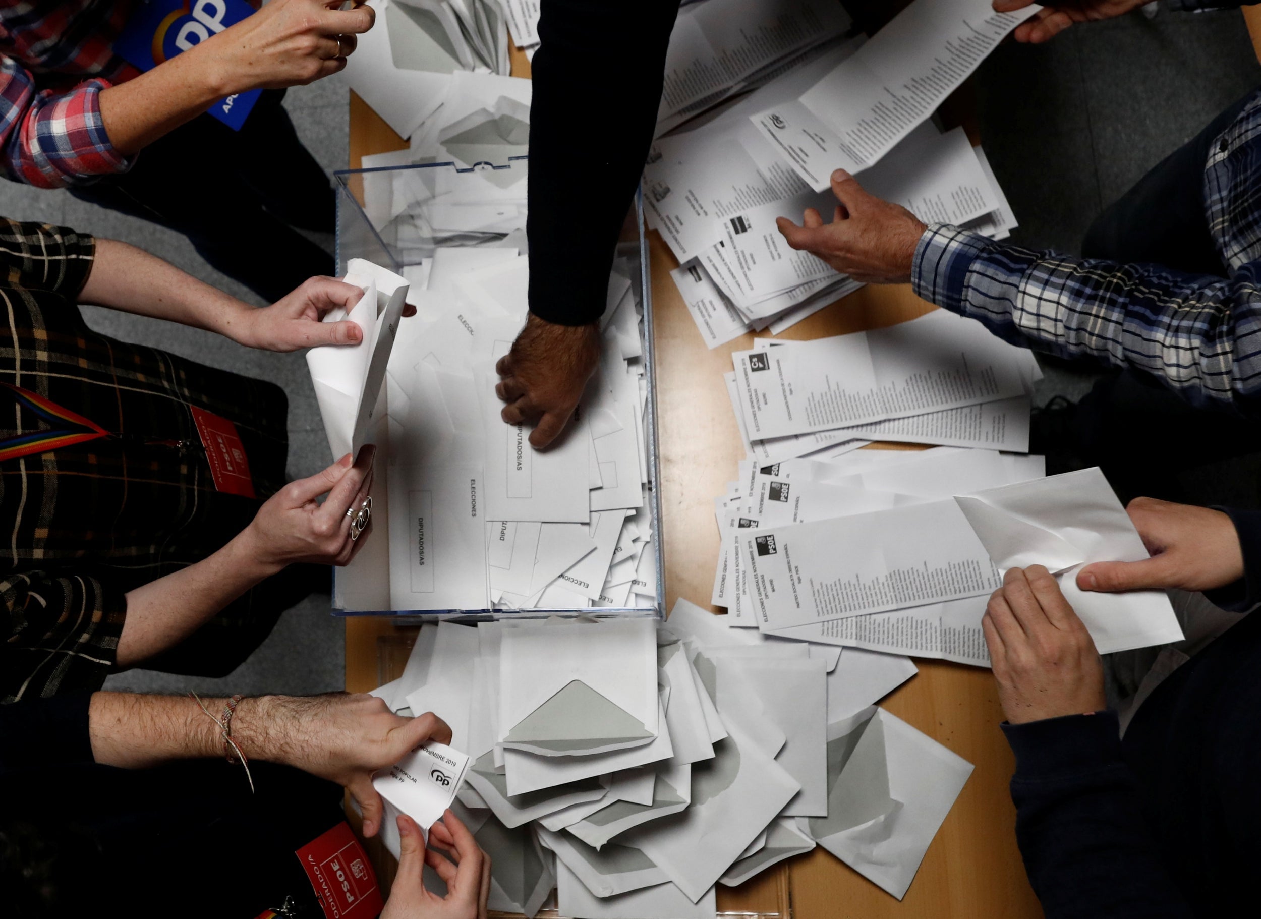 Members of an electoral commission count voting ballots during Spain’s general election at a polling station in Madrid, Spain