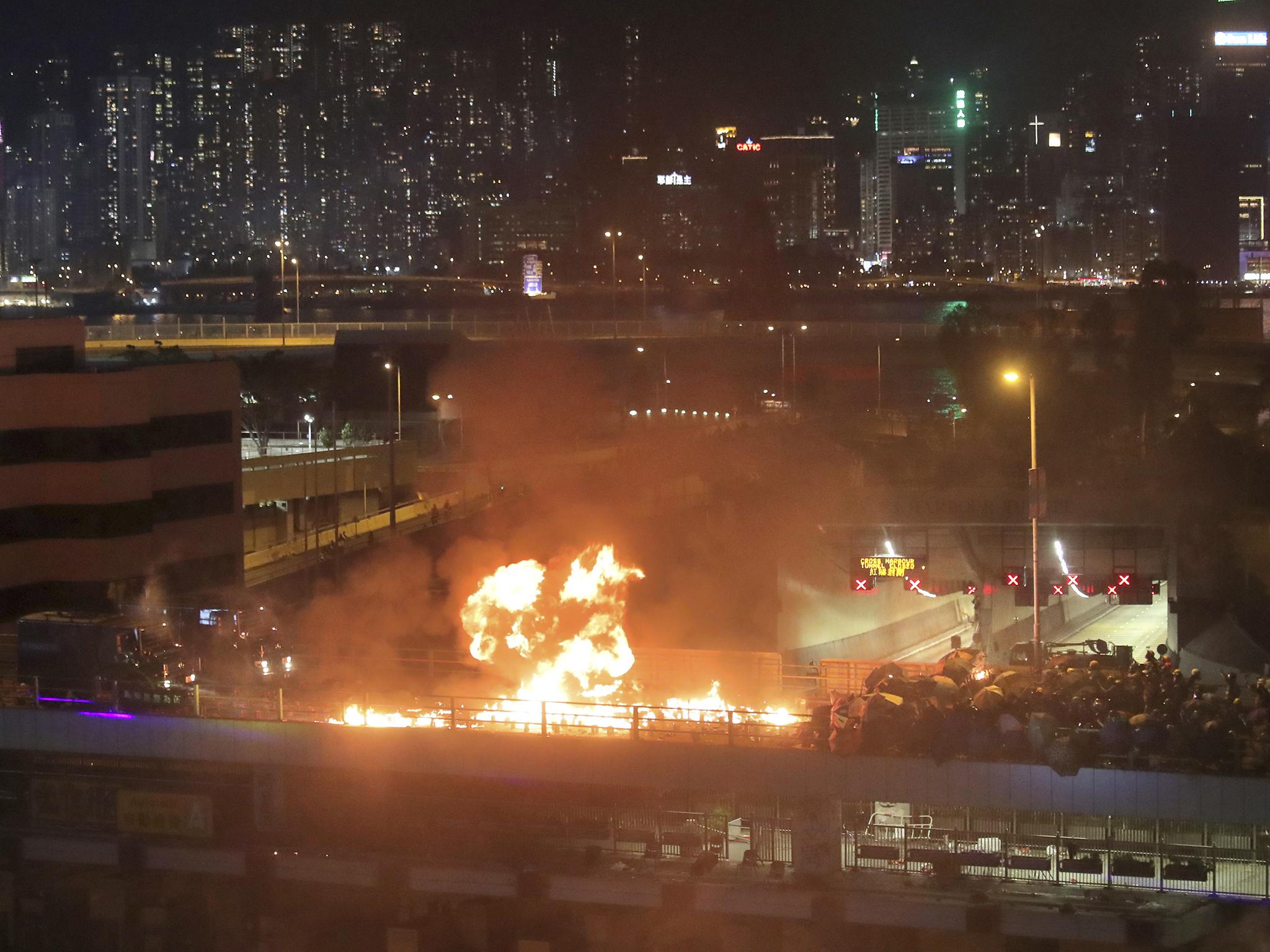 Protesters set alight a bridge separating them from riot police officers