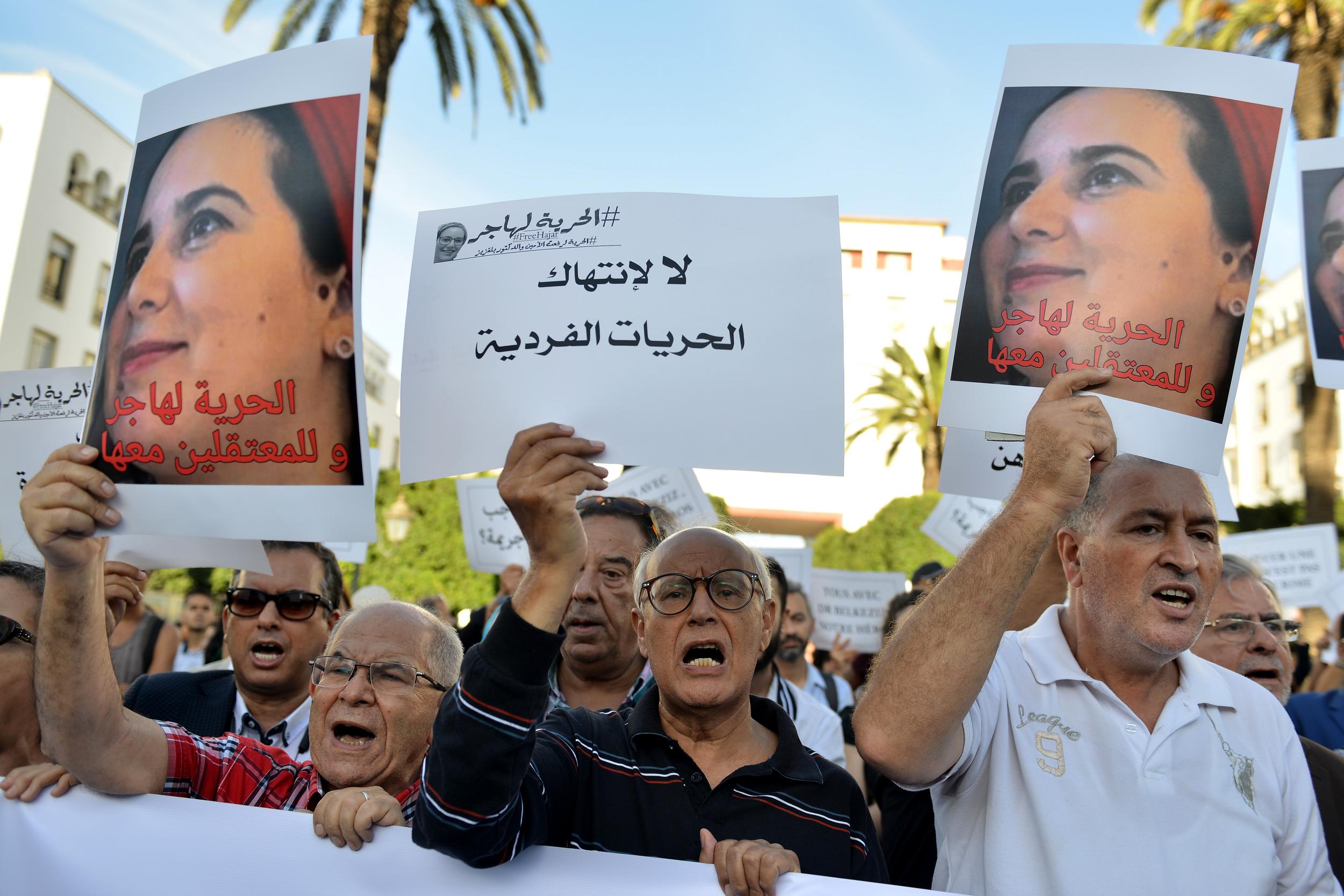 Demonstrators hold up signs during a protest calling to free Hajar Raissouni (AFP via Getty)