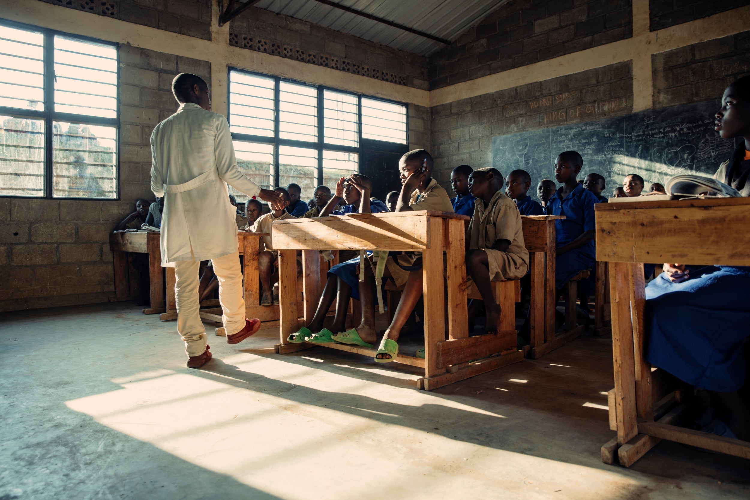 A grade 3 teacher holds a class in Kinyarwanda at GS Gasaka school in Nyamagabe district. The school is one of several projects funded by Educate A Child (EAC) a global programme run by the EAA Foundation. While some neighbouring countries also shouldering the burden of conflict have seen their citizens push back against the influx of refugees, Rwanda appears to have created an environment of relative calm, with both children from the refugee community and the host nation sat side by side in class.