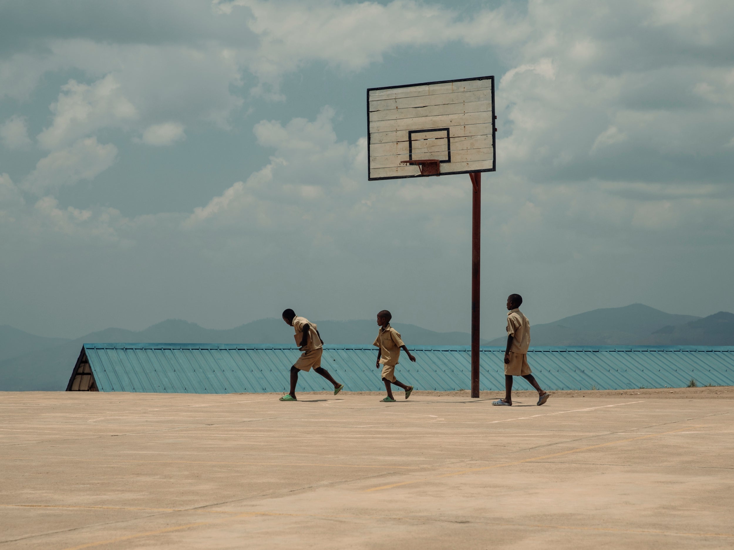 Pupils playing football at GS Gasaka school, perched high above the hard carved shadows of the terraced landscape, on one of Rwanda’s thousand hills. This is one of the schools funded by the partnership between EAA and UNHCR. They have constructed two other schools, with 162 classrooms, and trained 1,108 teachers, enabling the enrolment of 12,984 children.