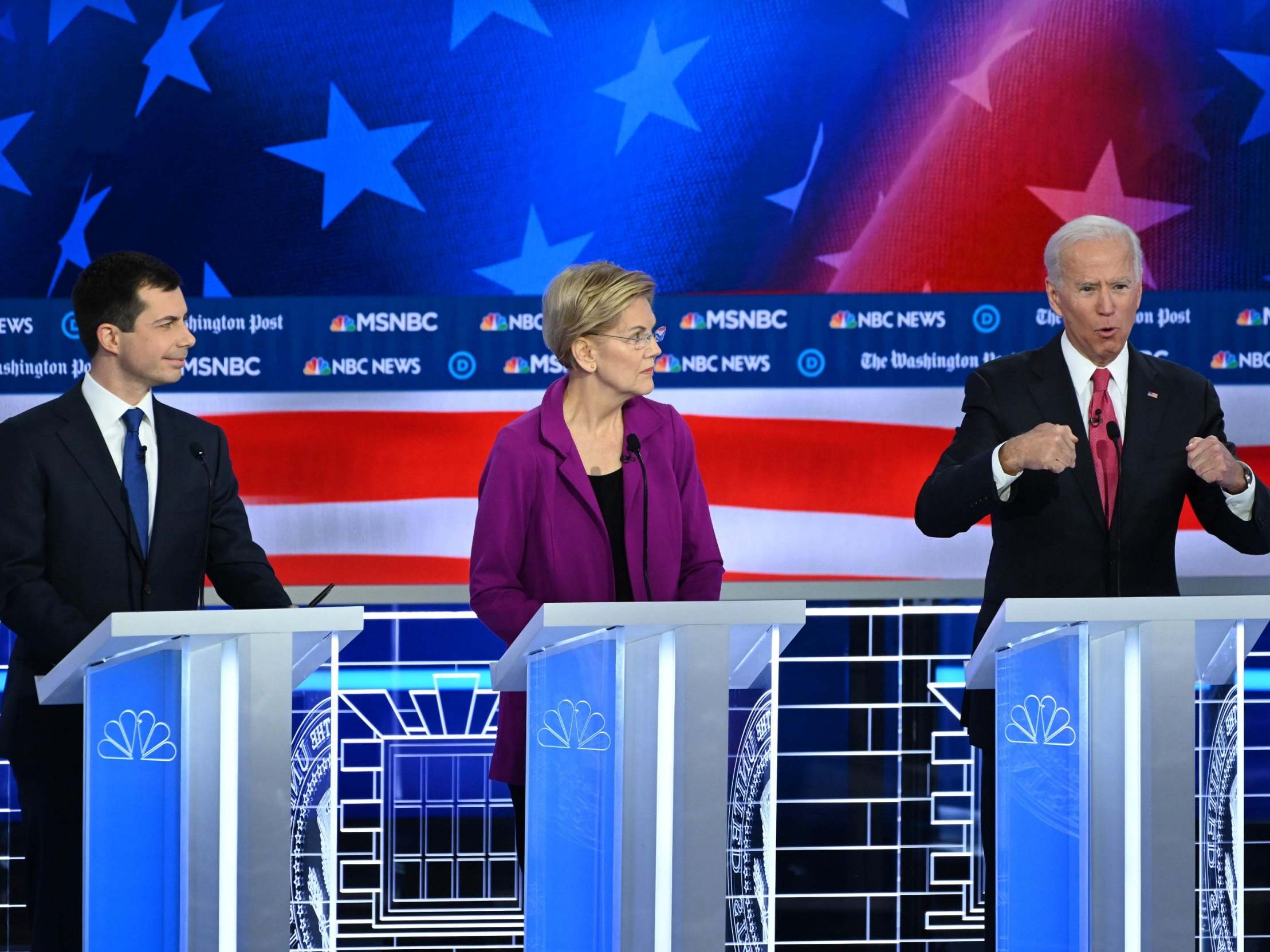 Democratic nomination hopefuls Pete Buttigieg (left) and Elizabeth Warren (centre) listen to former Vice President Joe Biden (AFP via Getty)