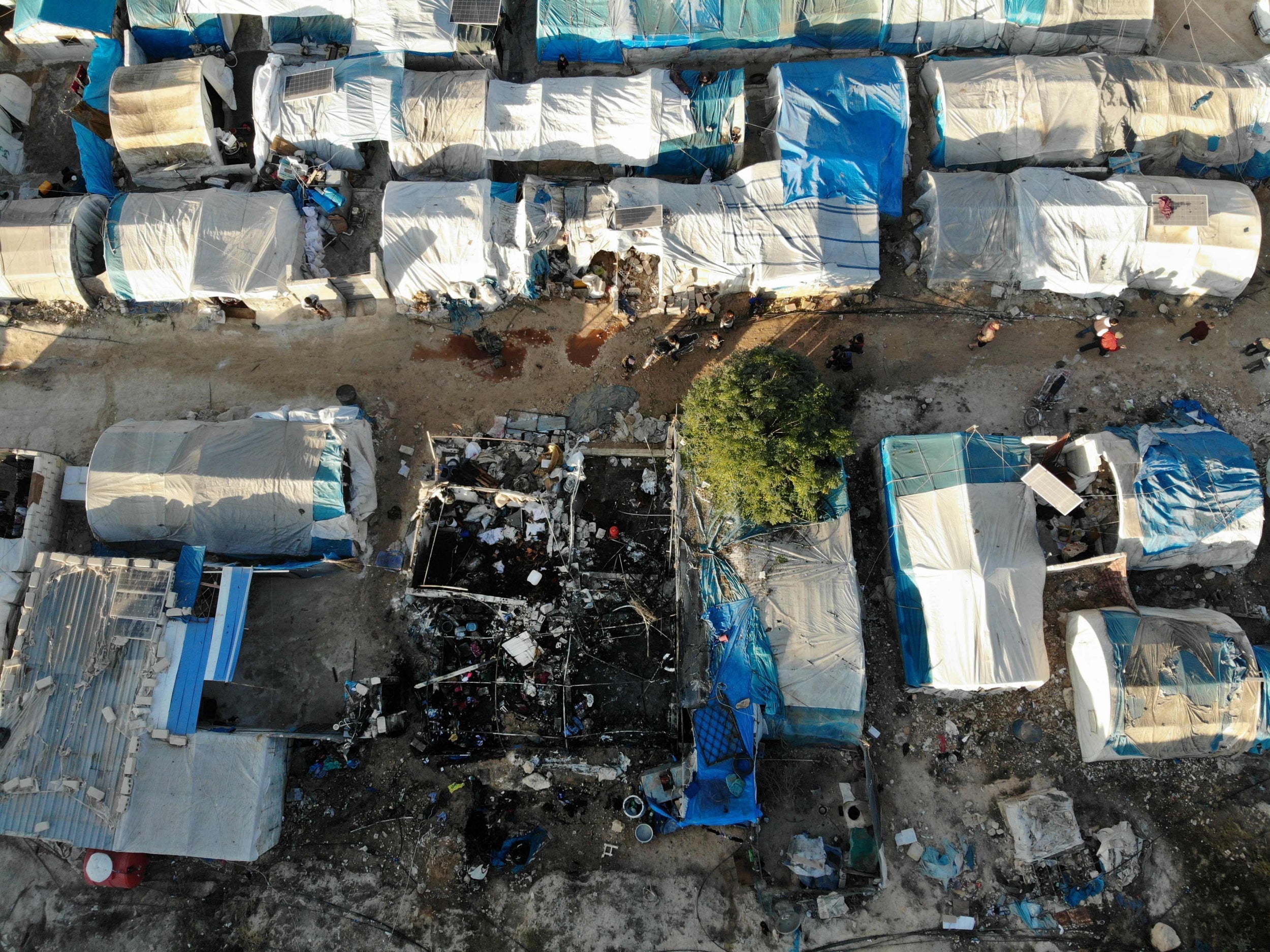 An aerial view taken shows the charred remains of a tent following Syrian regime bombardment on a makeshift camp in the village of Qah