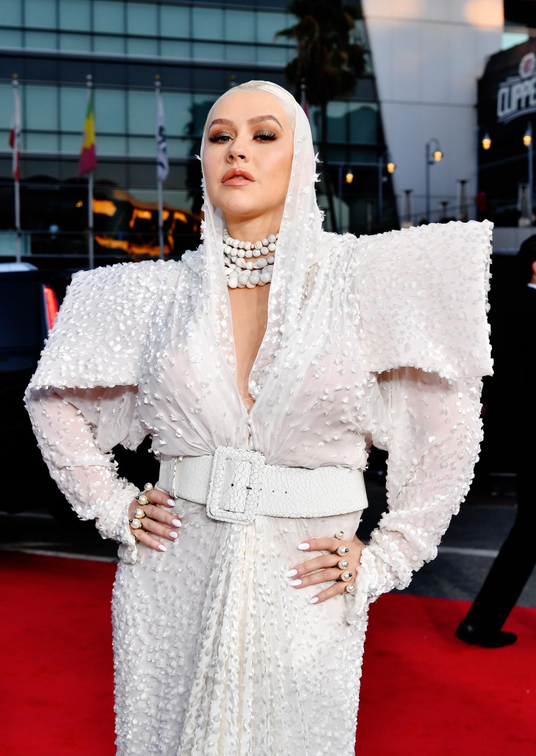 The 'Genie in a bottle' singer's red carpet look defied proportions with its bulbous shoulder pads and oversized sleeves. Aguilera completed the look with rows of jingling necklaces and a square buckle belt.