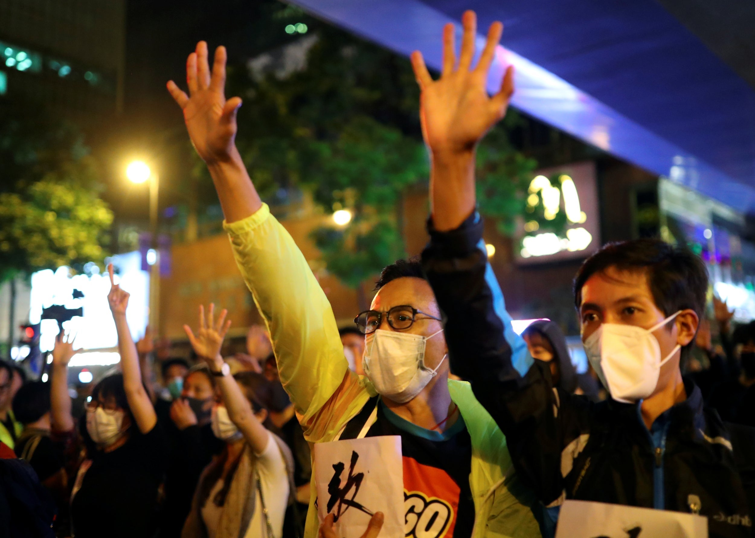 Protesters hold up five fingers outside the Polytechnic University in Hong Kong, representing the ‘five demands’ of the movement, after a resounding election victory for pro-democracy parties