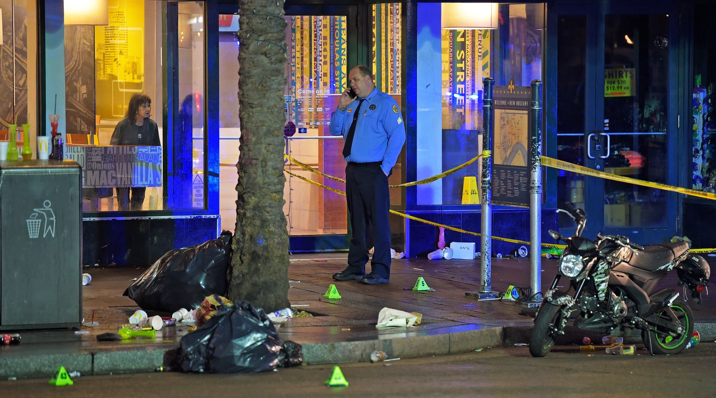 A woman looks out from inside a McDonald's fast food restaurant as New Orleans police investigate the scene of the shooting