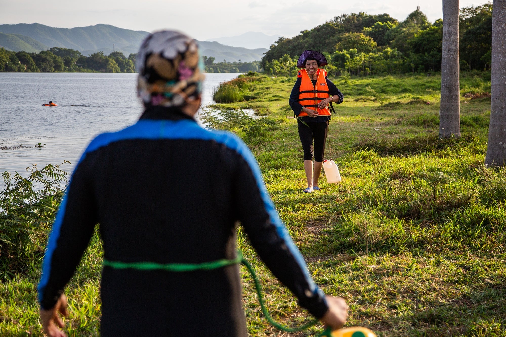 Women meet up in the evening on the banks of the Perfume River in Hue. A group of them swim every morning and evening in the river and work to collect rubbish and keep the riverside clean