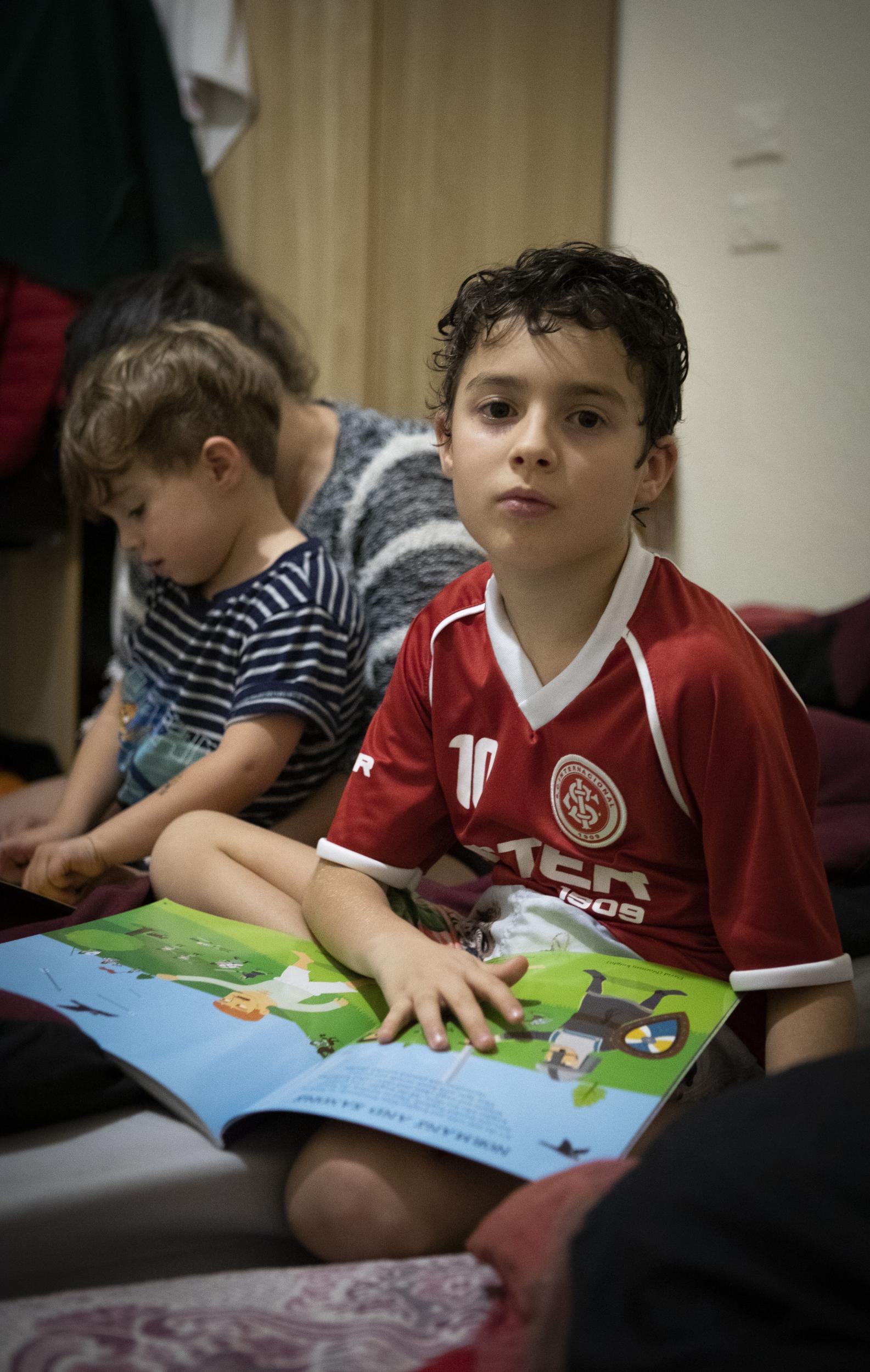 Will, 10, sits in the bedroom he shares with his parents and younger brother